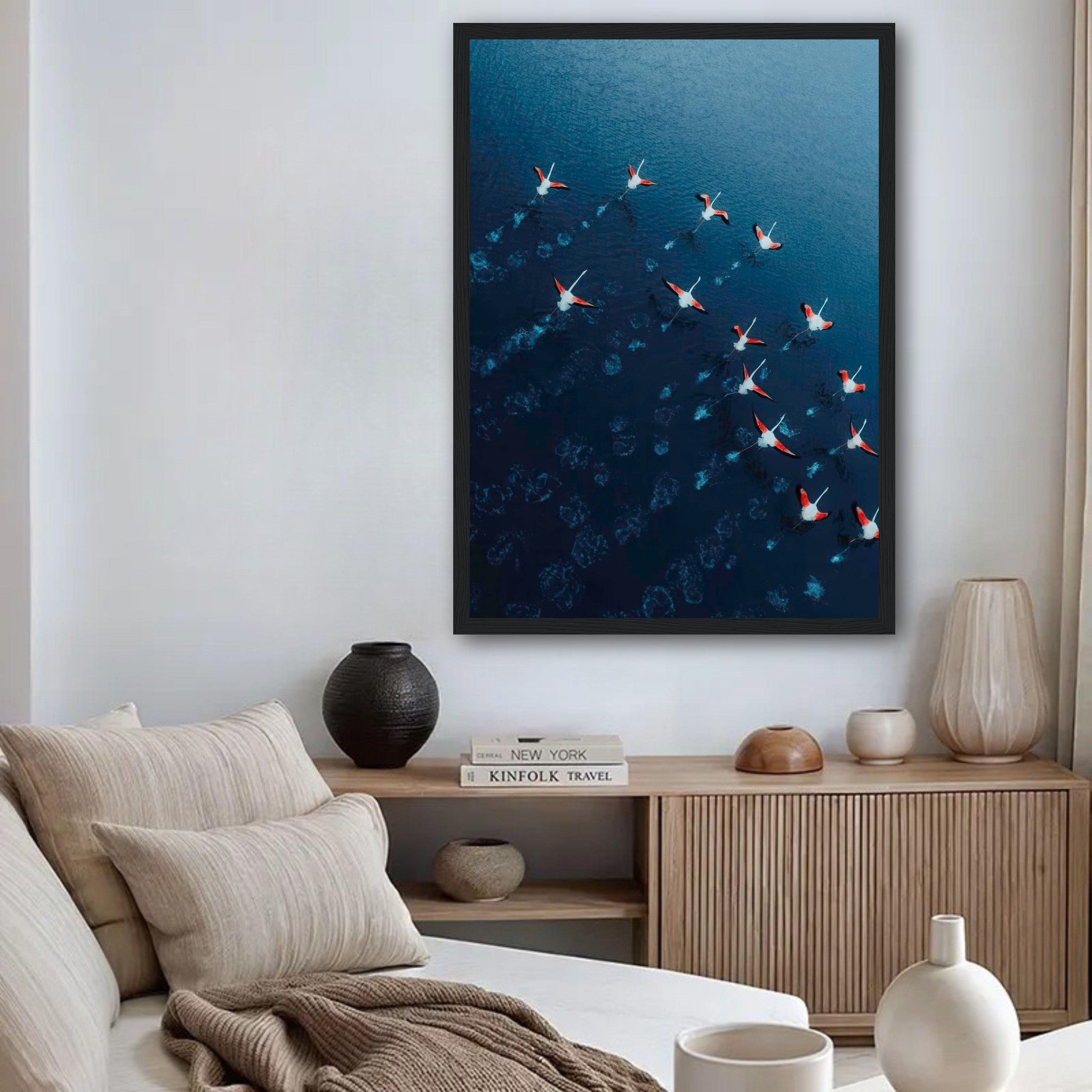 Framed print of flamingos flying over deep blue waters, adding elegance and serenity to modern decor.