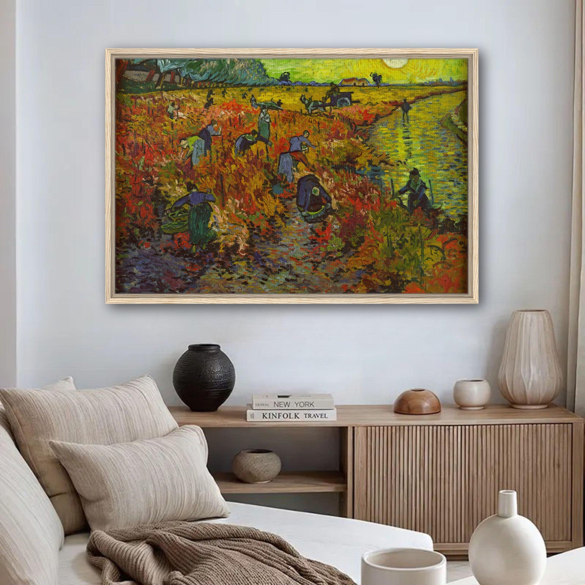 The Red Vineyard Van Gogh framed canvas print displayed in a cozy living room setting with neutral decor.