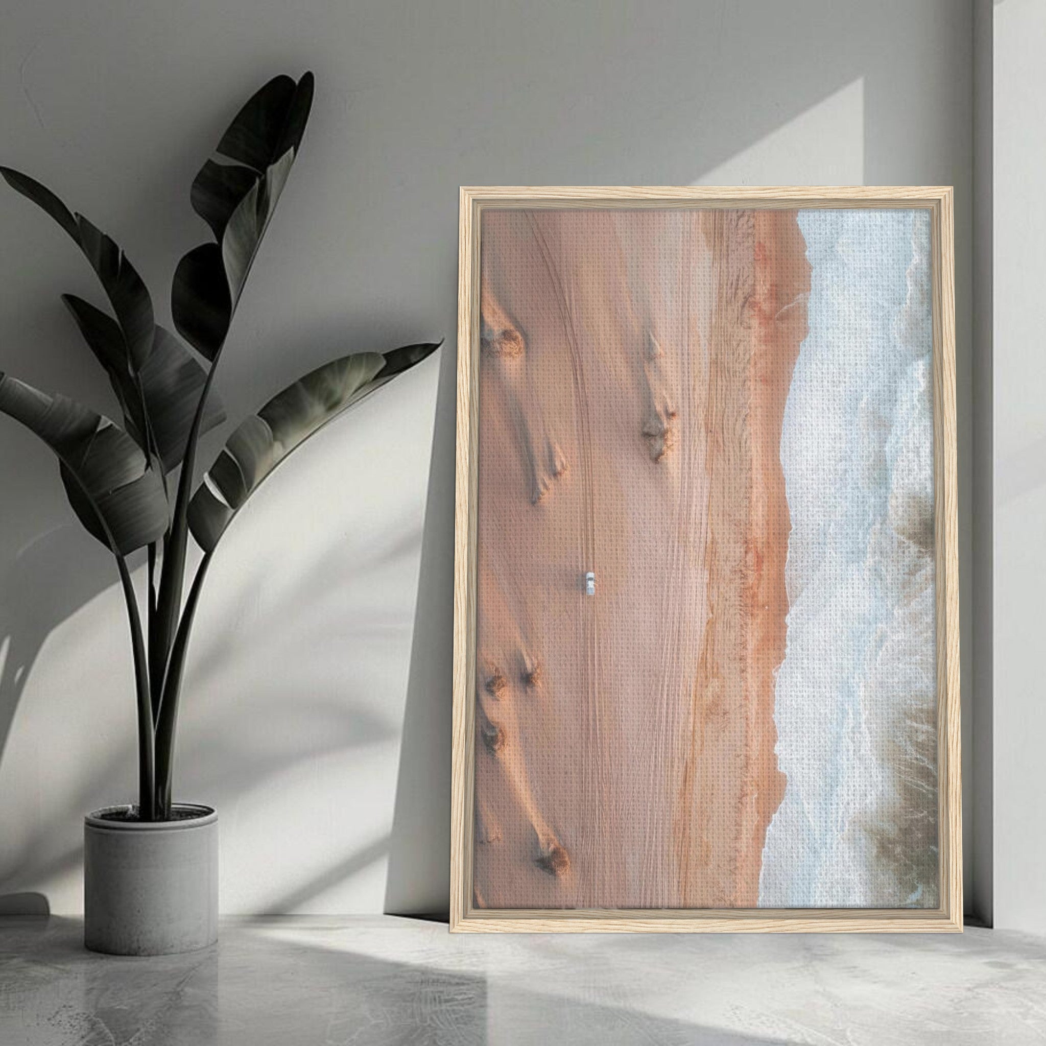 Framed canvas print of desert sands meeting ocean waves, showcasing serene natural beauty in interior decor.