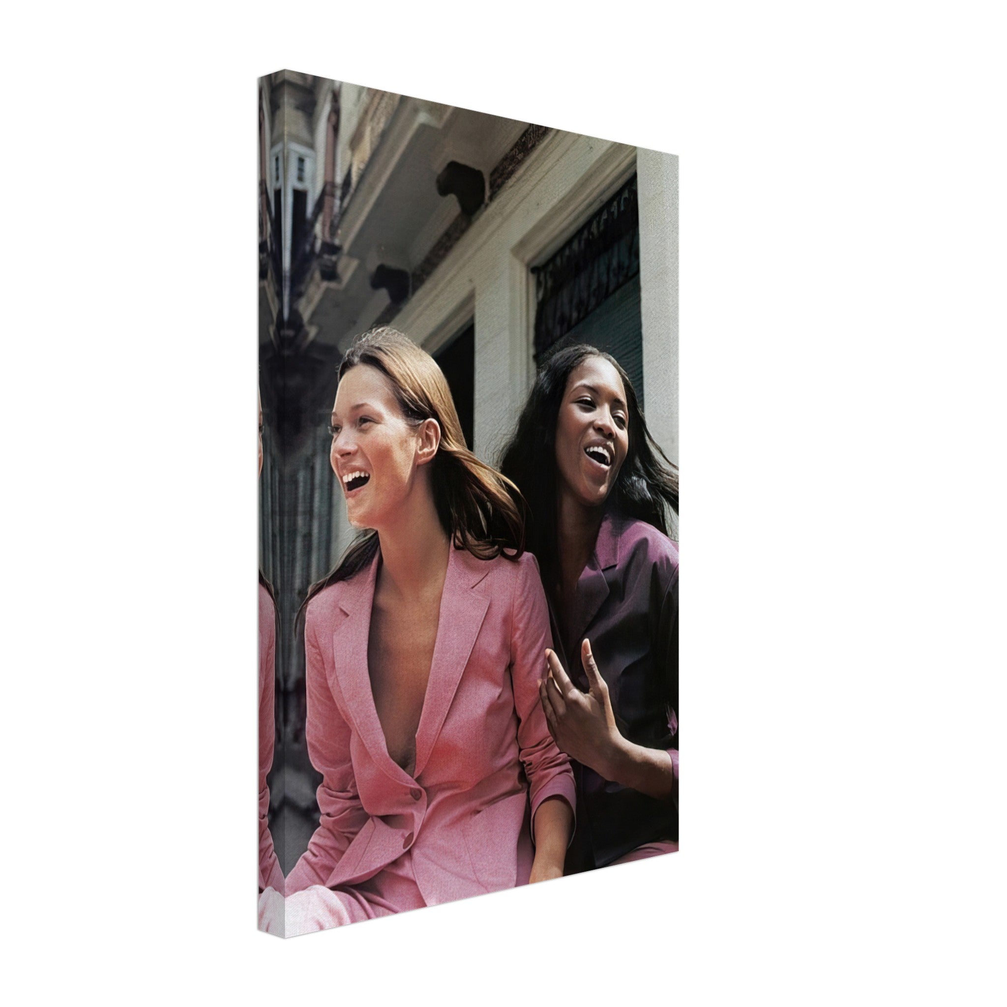 Naomi Campbell and Kate Moss laughing in stylish suits on canvas print, celebrating iconic fashion history.