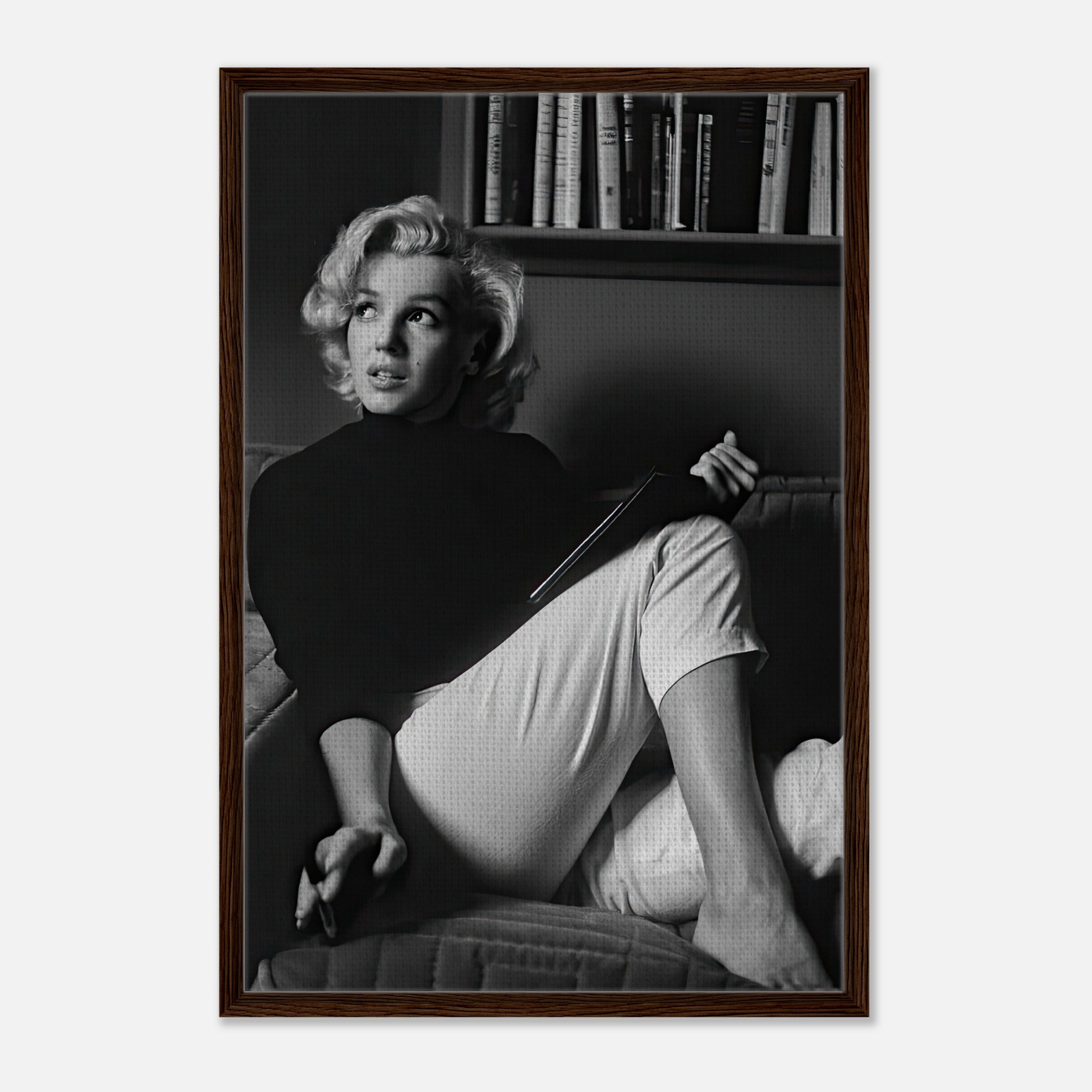 Marilyn Monroe reading a book in a framed black-and-white canvas print, showcasing elegance and sophistication.