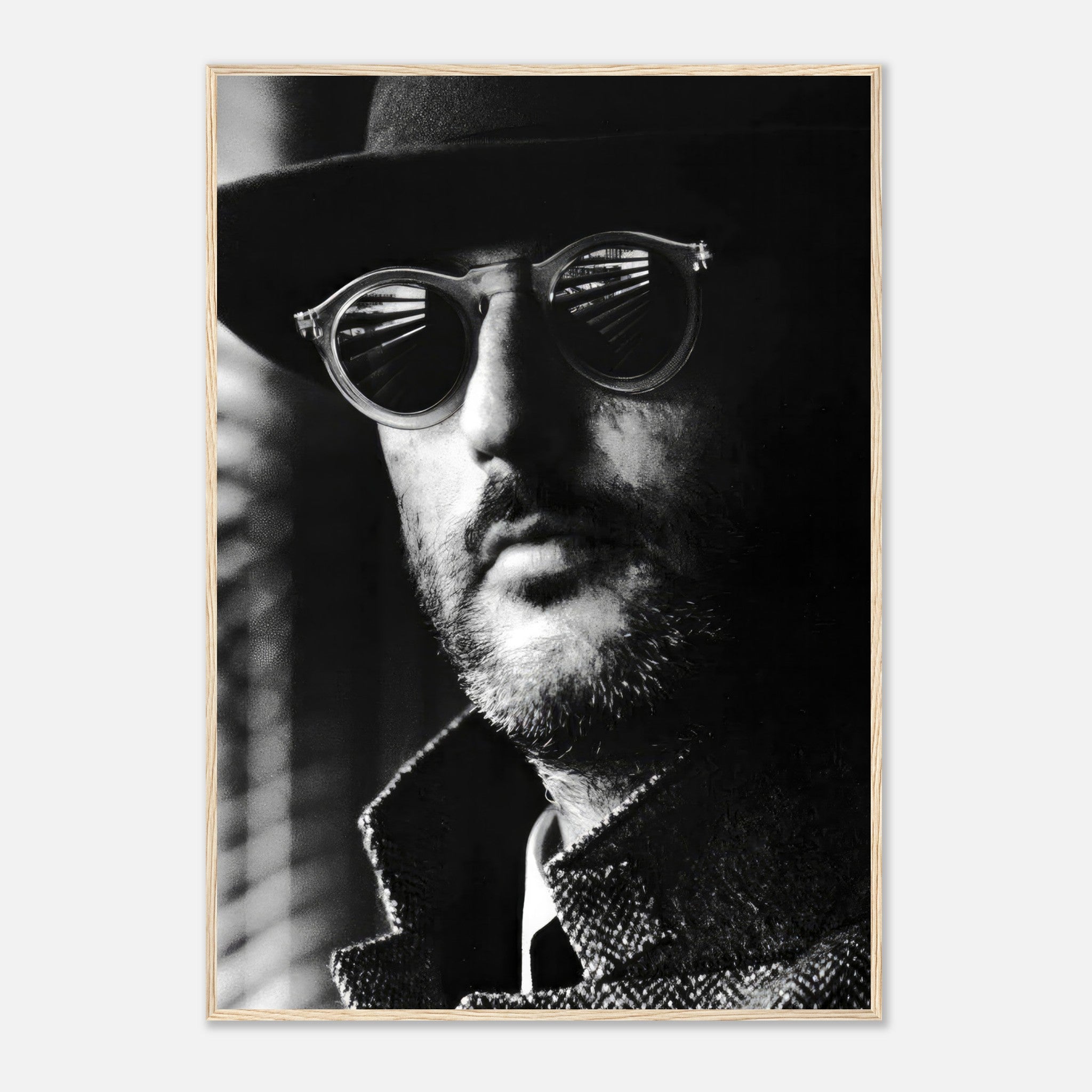 Framed black-and-white print of a man wearing dark sunglasses and a hat, exuding sophistication and mystery.