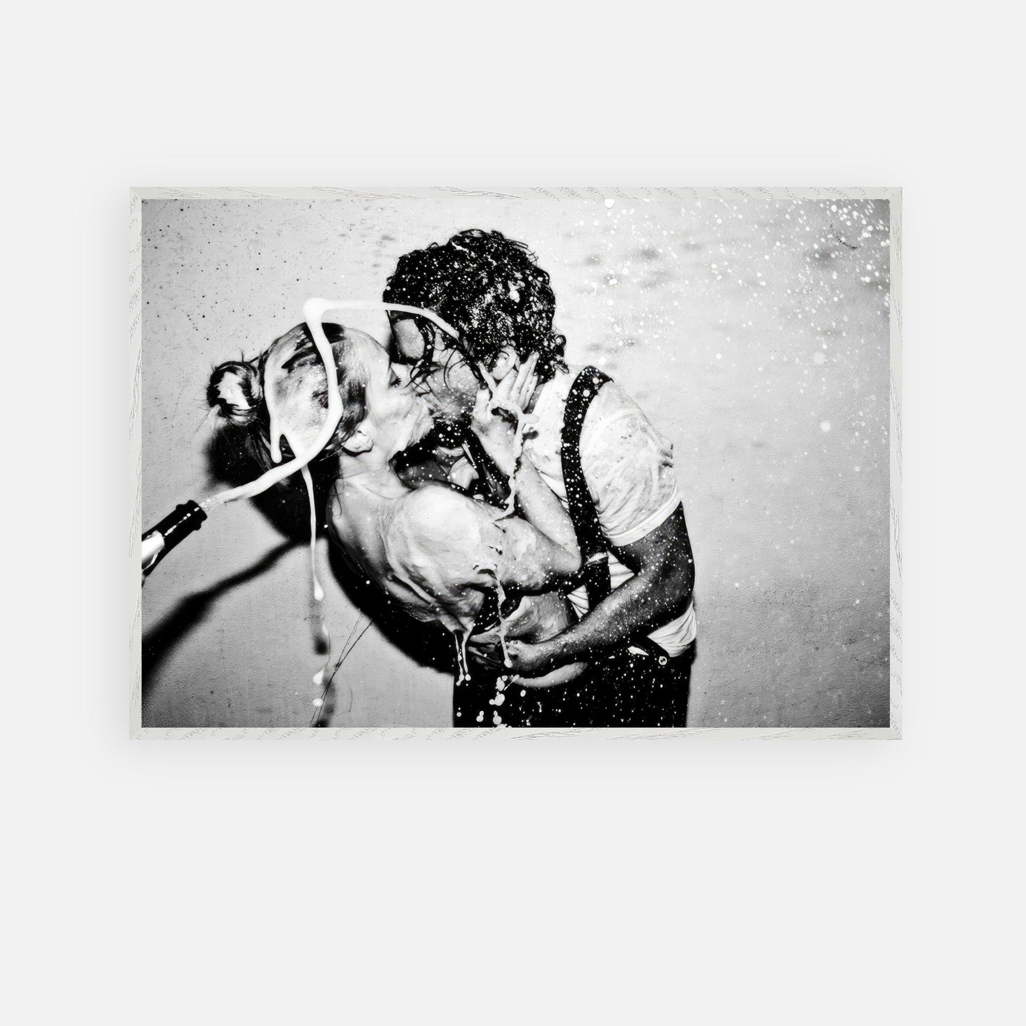 Black-and-white fine art print of Johnny Depp and Kate Moss sharing a passionate kiss with champagne splashing.