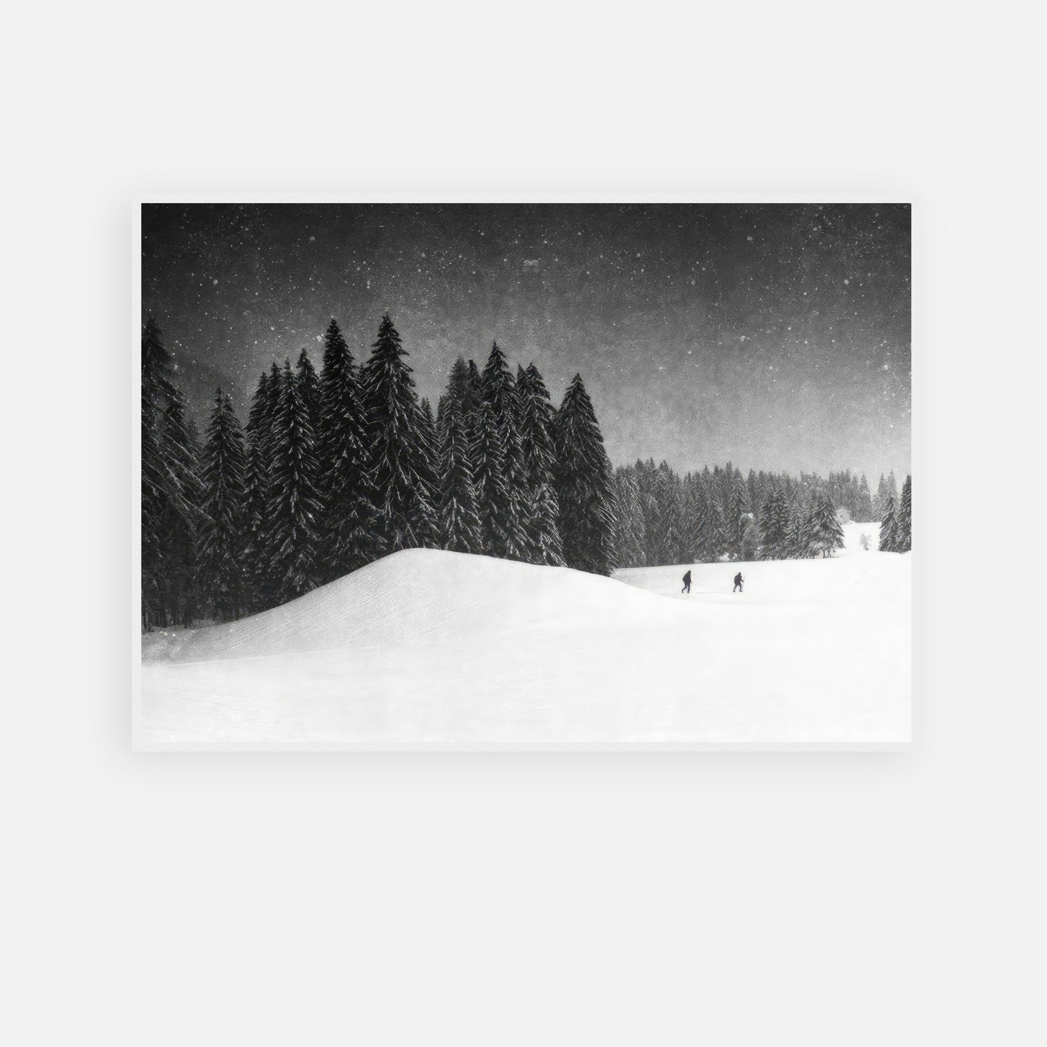 Black-and-white framed print of a snowy forest with skiers in winter landscape.