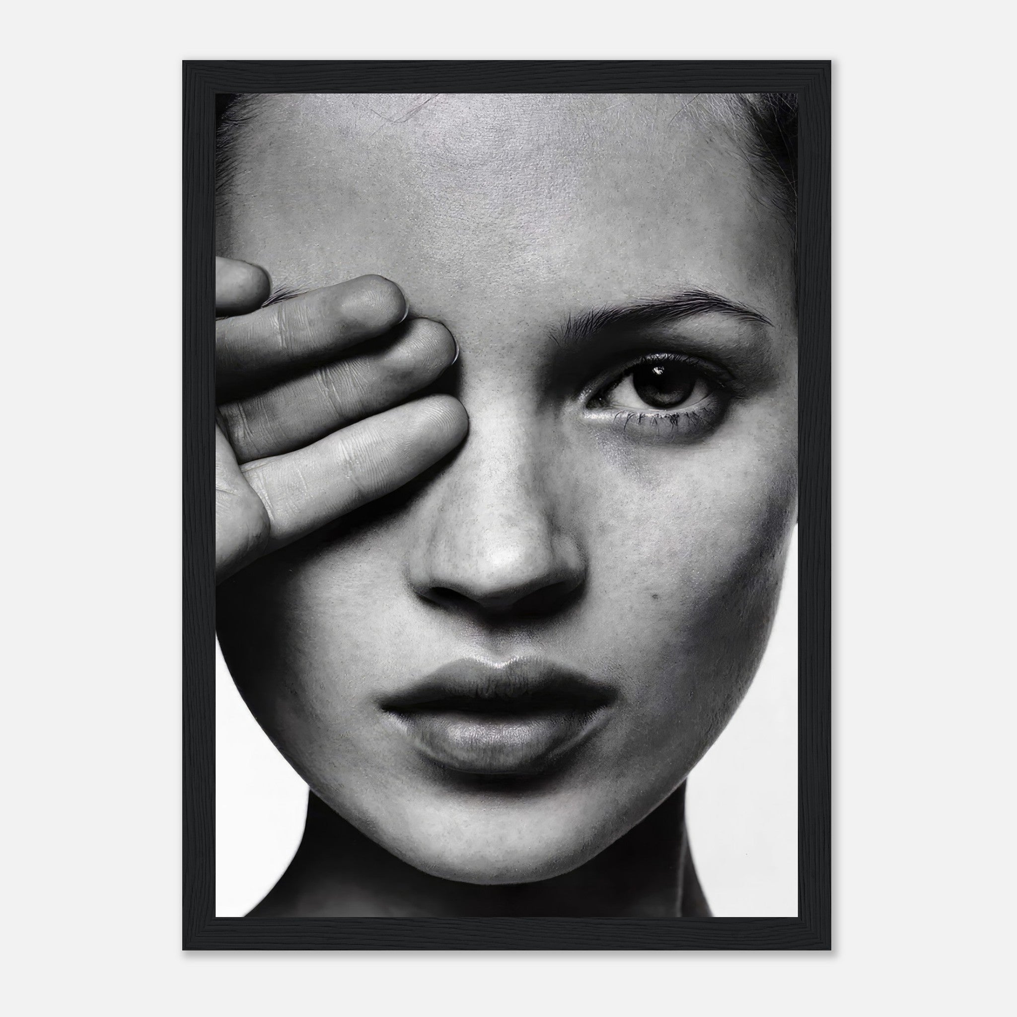 Black and white framed print of a woman covering one eye, showcasing striking monochromatic portrait and elegant design.
