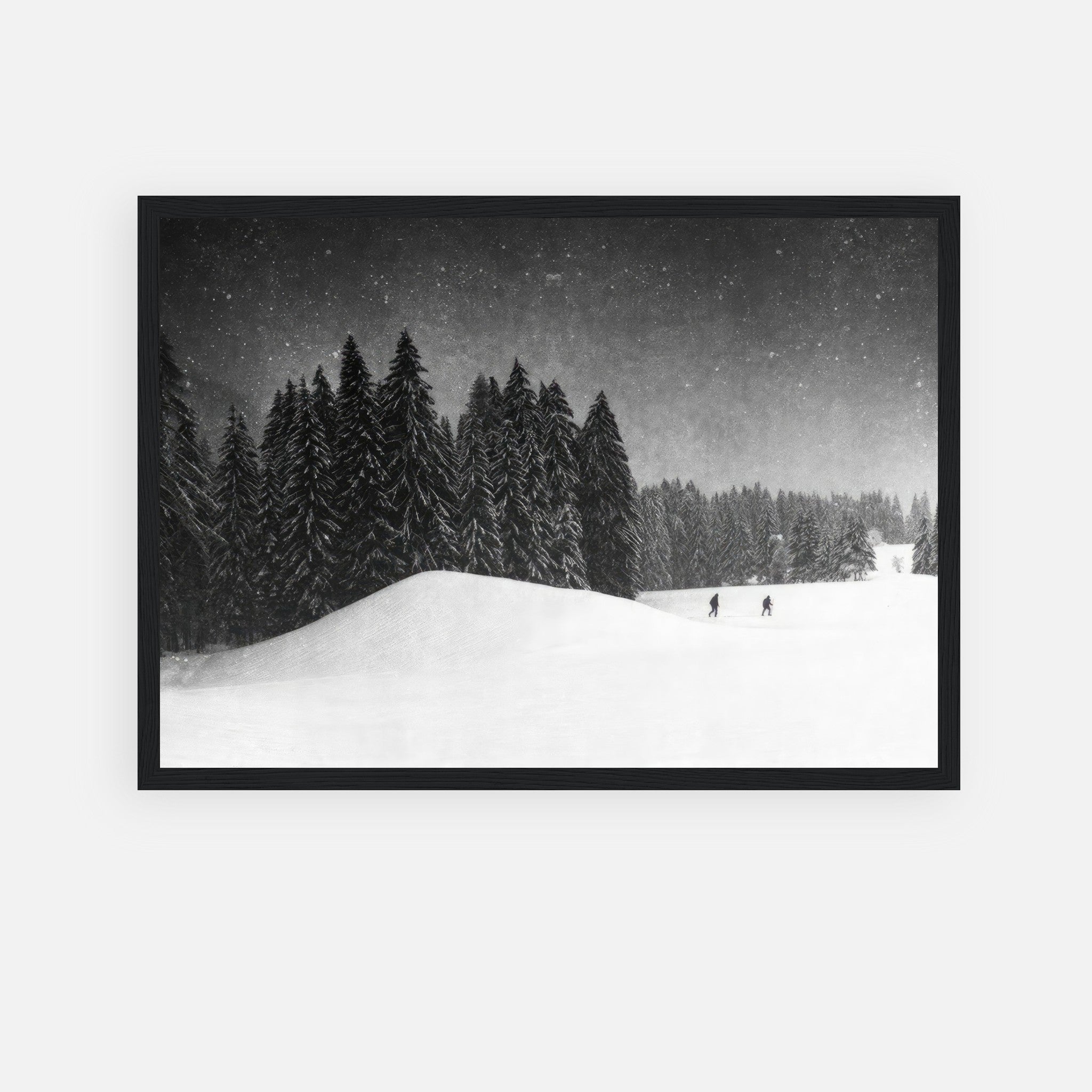 Black-and-white framed print of serene winter landscape with snow-covered evergreens and skiers.