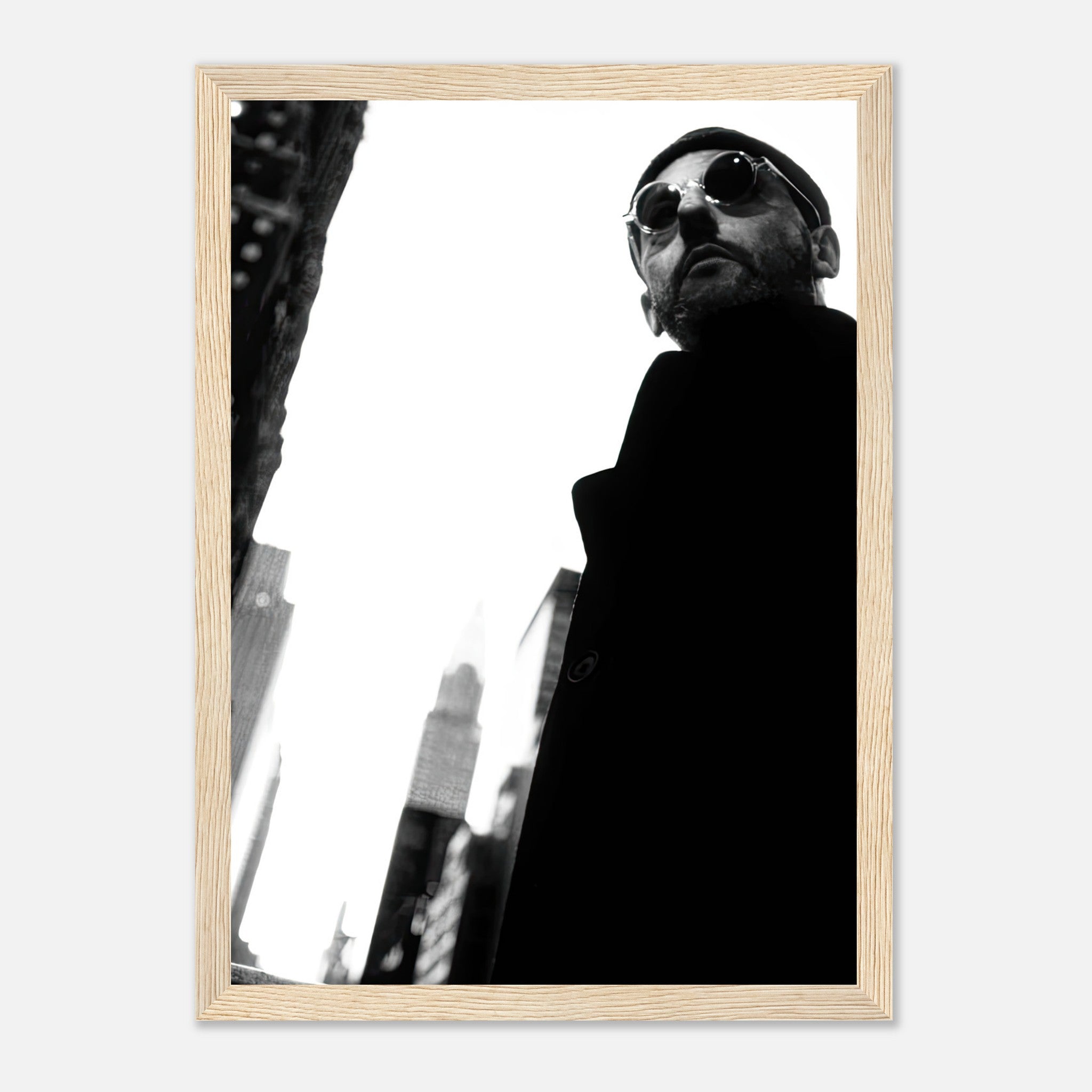 Black-and-white framed print of Jean Reno, stylishly posed against an urban backdrop, capturing cinematic essence.
