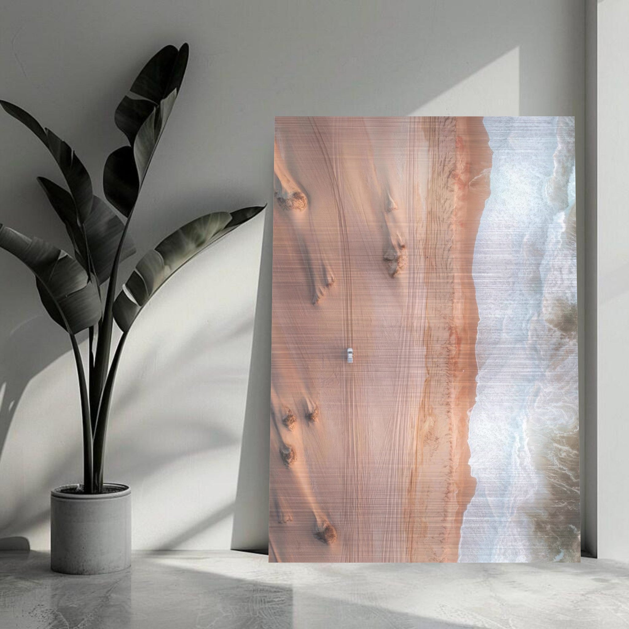 Aerial view of desert meeting ocean on brushed metal print, showcasing warm sands and crashing waves.