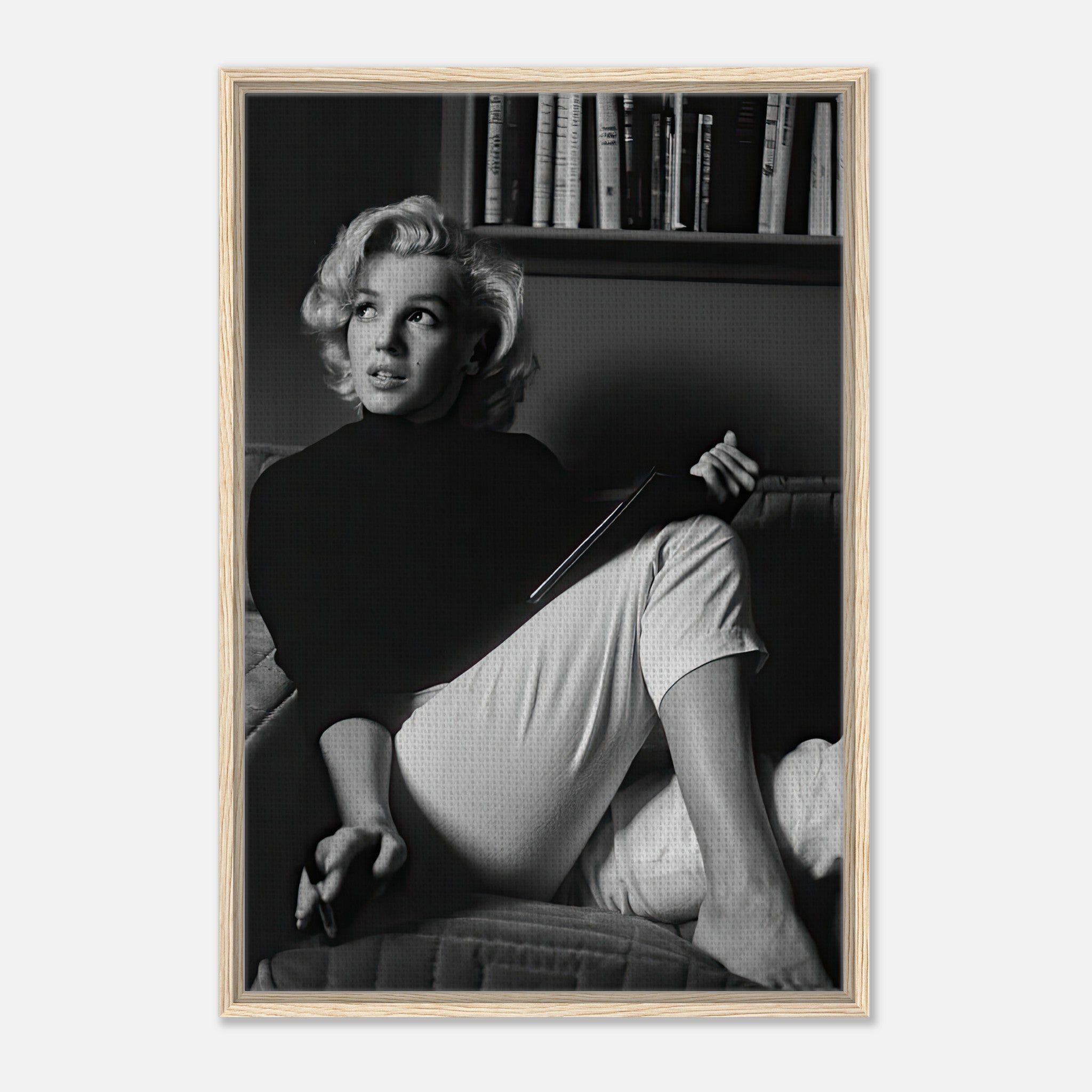 Marilyn Monroe reading a book in a framed black-and-white canvas print, showcasing elegance and sophistication.