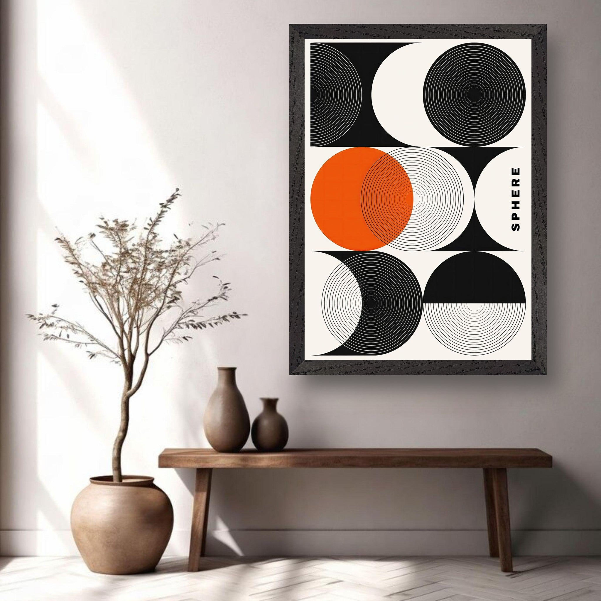 Abstract geometric sphere art print with concentric circles in black, white, and vibrant orange, framed and displayed in a minimalist setting.
