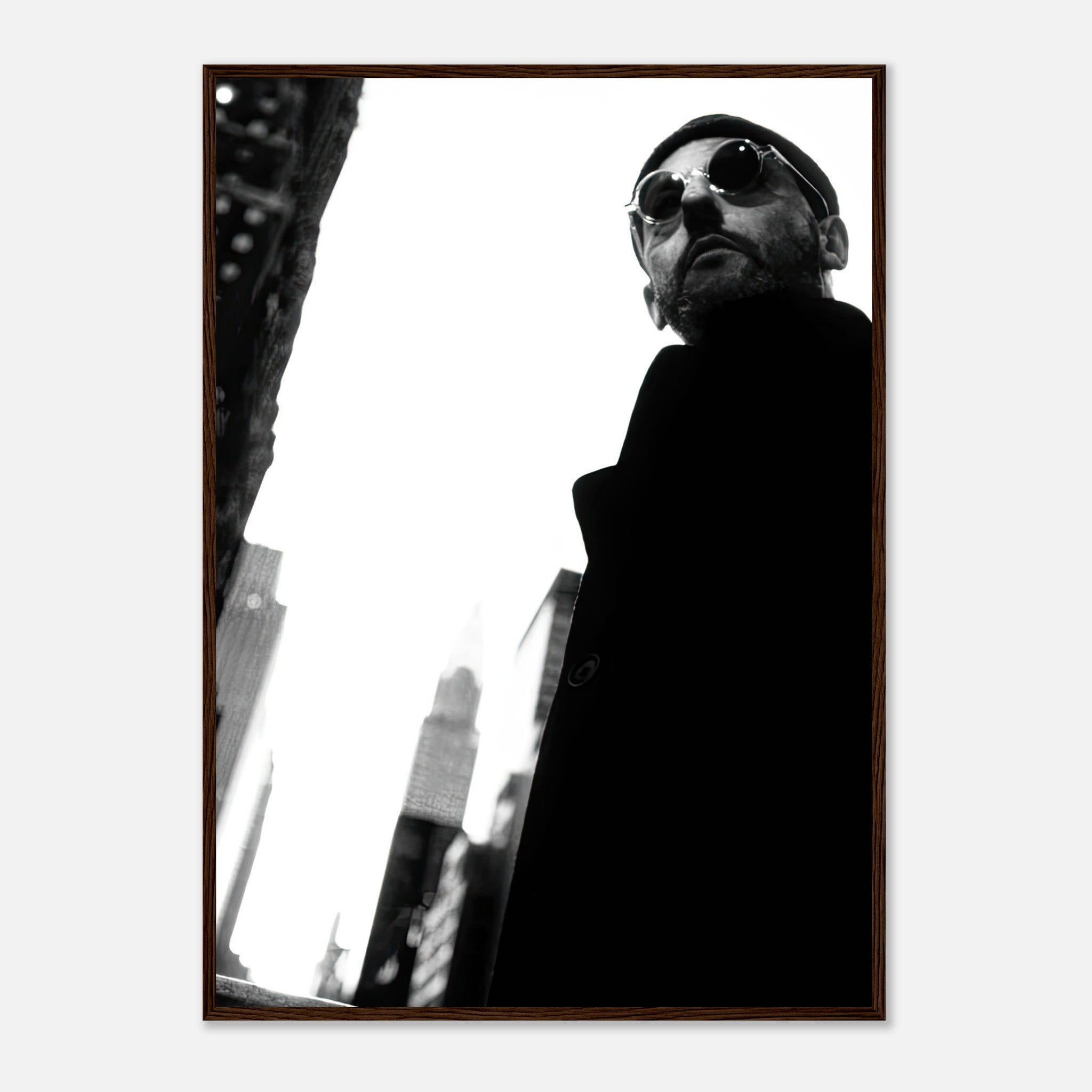 Framed black-and-white print of Jean Reno in urban setting, showcasing cinematic artistry and timeless style.