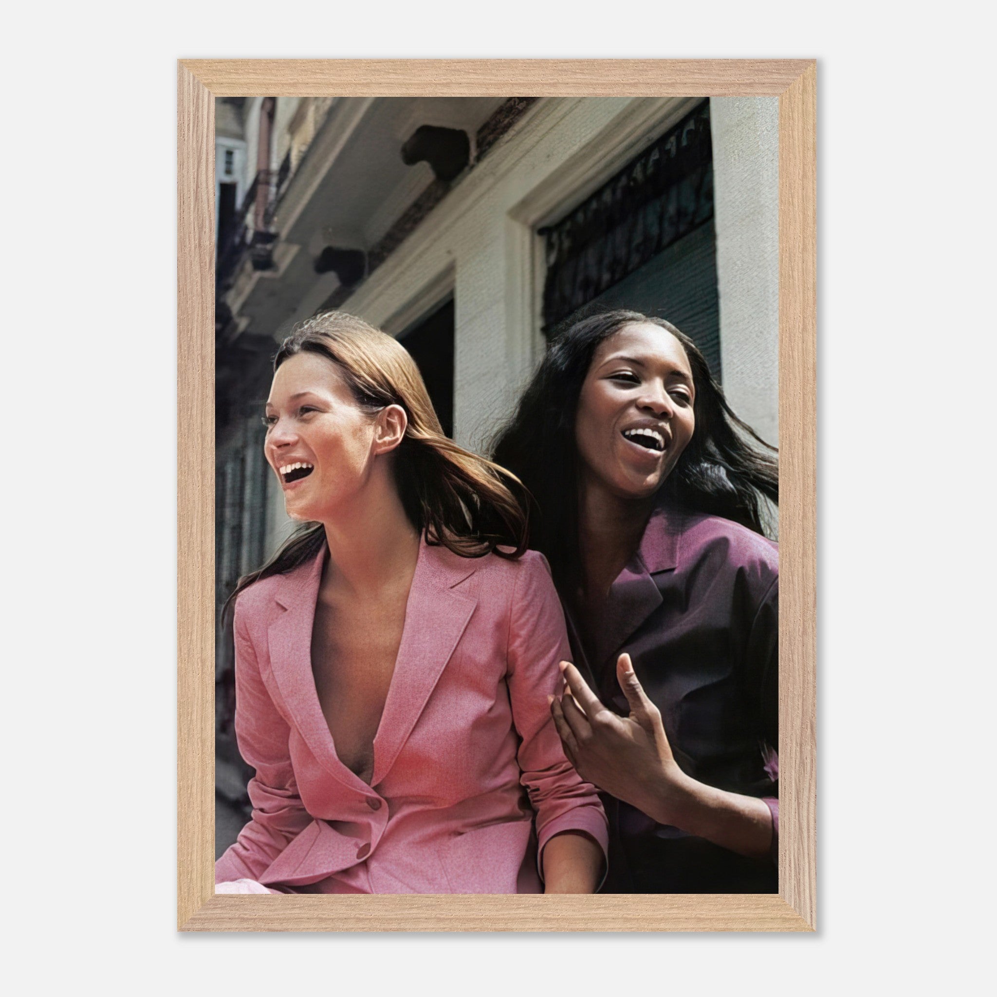 Naomi Campbell and Kate Moss laughing together in a vintage framed print capturing iconic fashion history.