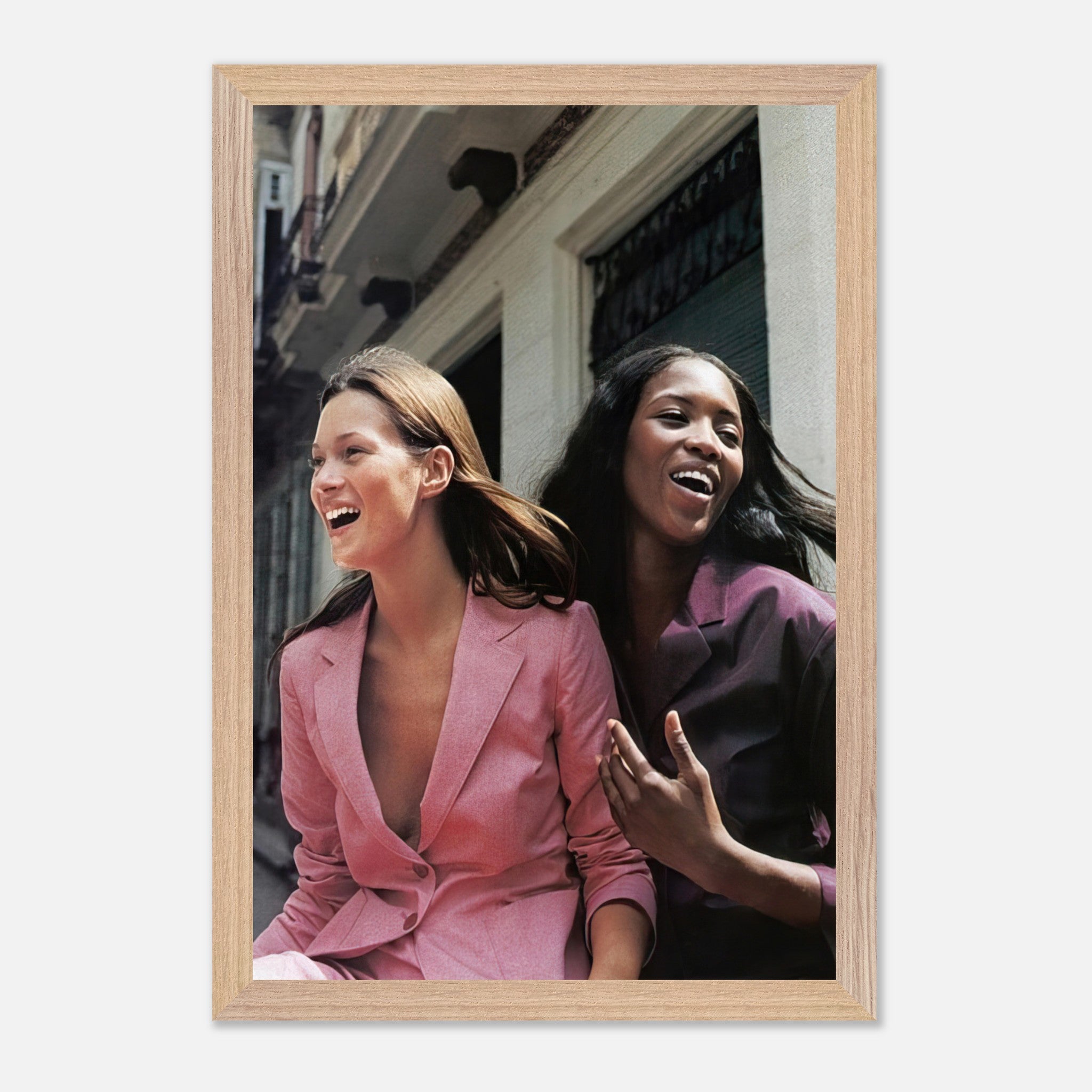 Naomi Campbell and Kate Moss laughing together in stylish outfits, capturing the essence of fashion's golden era.
