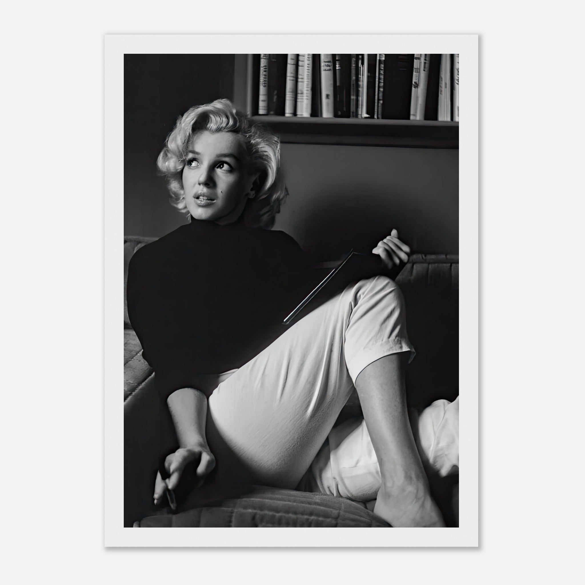Framed print of Marilyn Monroe reading a book, capturing vintage Hollywood glamour and elegance.
