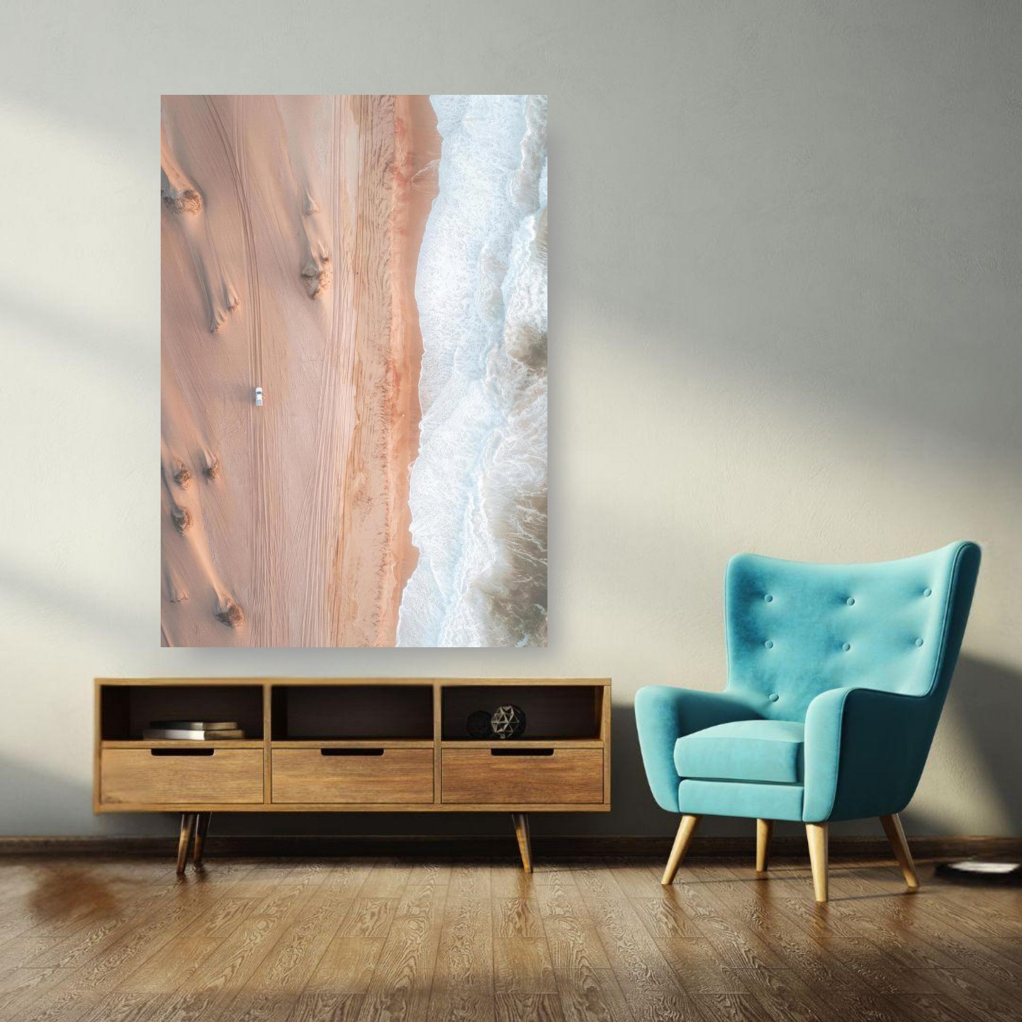 Drone photography poster showing desert dunes meeting ocean waves in a modern living room setting.