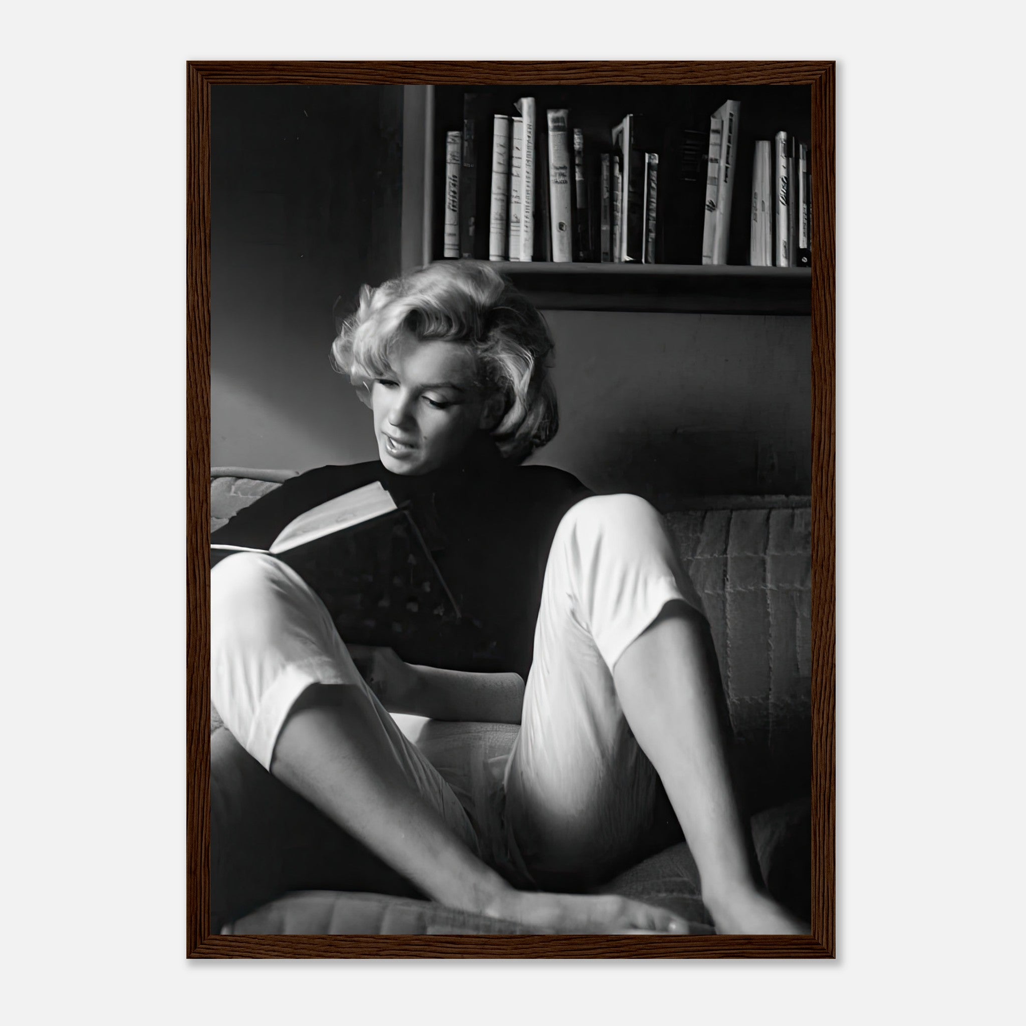 Marilyn Monroe reading a book at home, framed black-and-white print, classic Hollywood elegance.