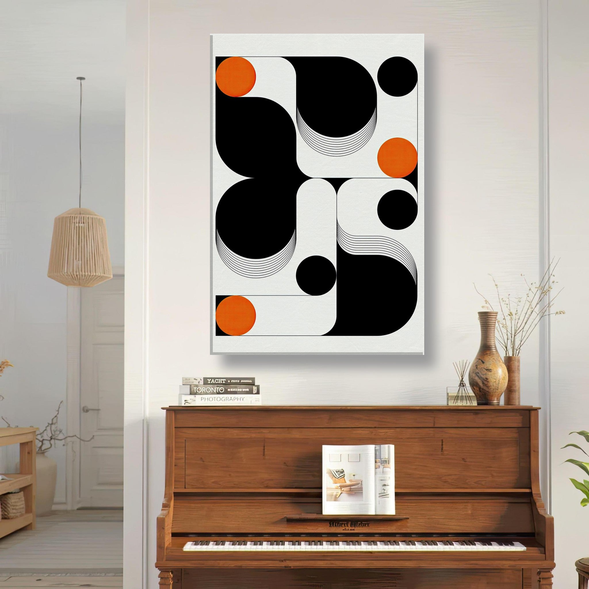Modern geometric abstract art canvas print featuring black, white, and vibrant orange shapes in a stylish living room.