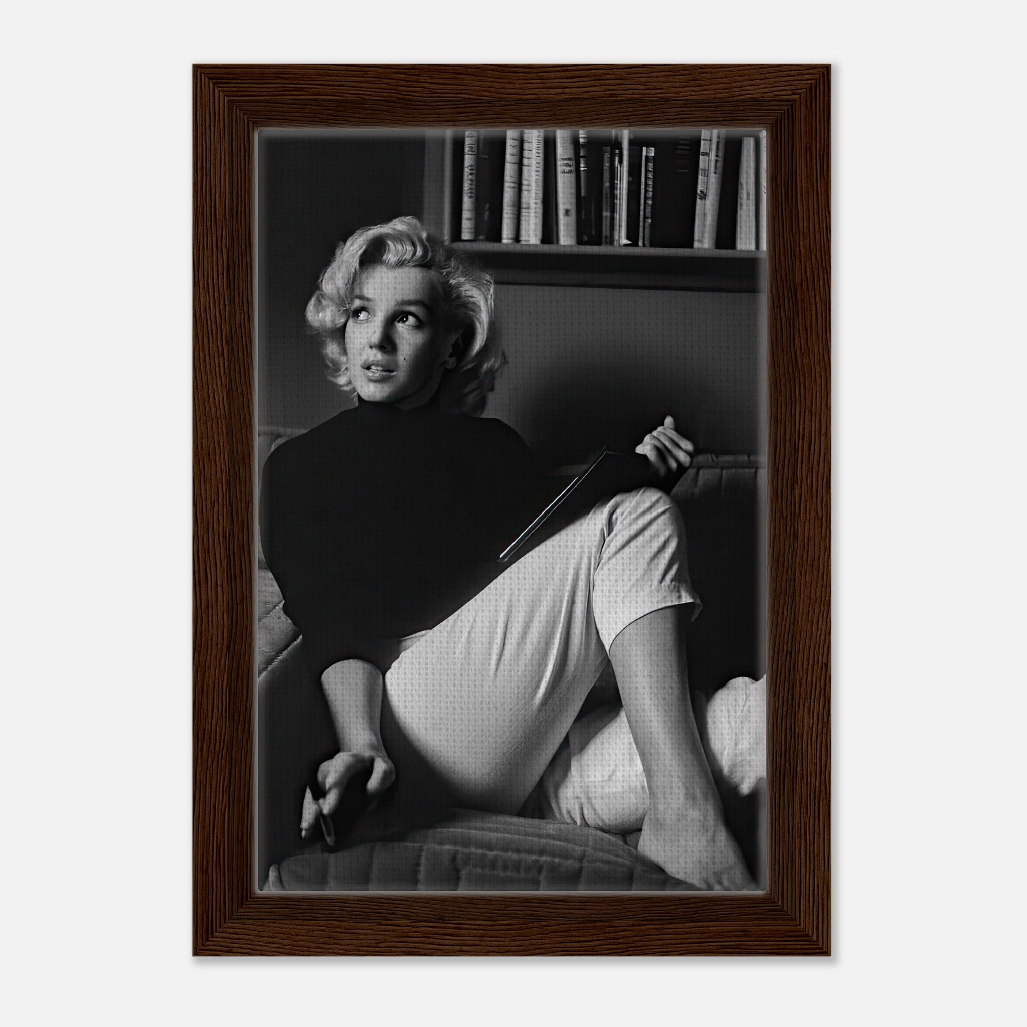Marilyn Monroe reading a book in a black-and-white framed canvas print, showcasing elegance and charm.