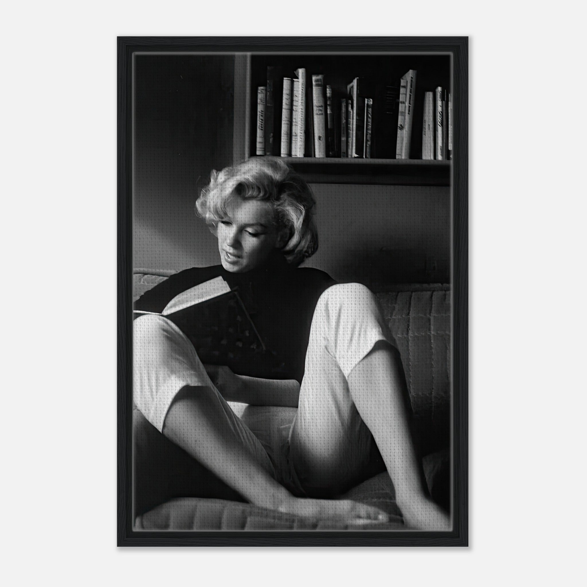 Marilyn Monroe reading a book in a serene moment, featured in a framed black-and-white canvas print.