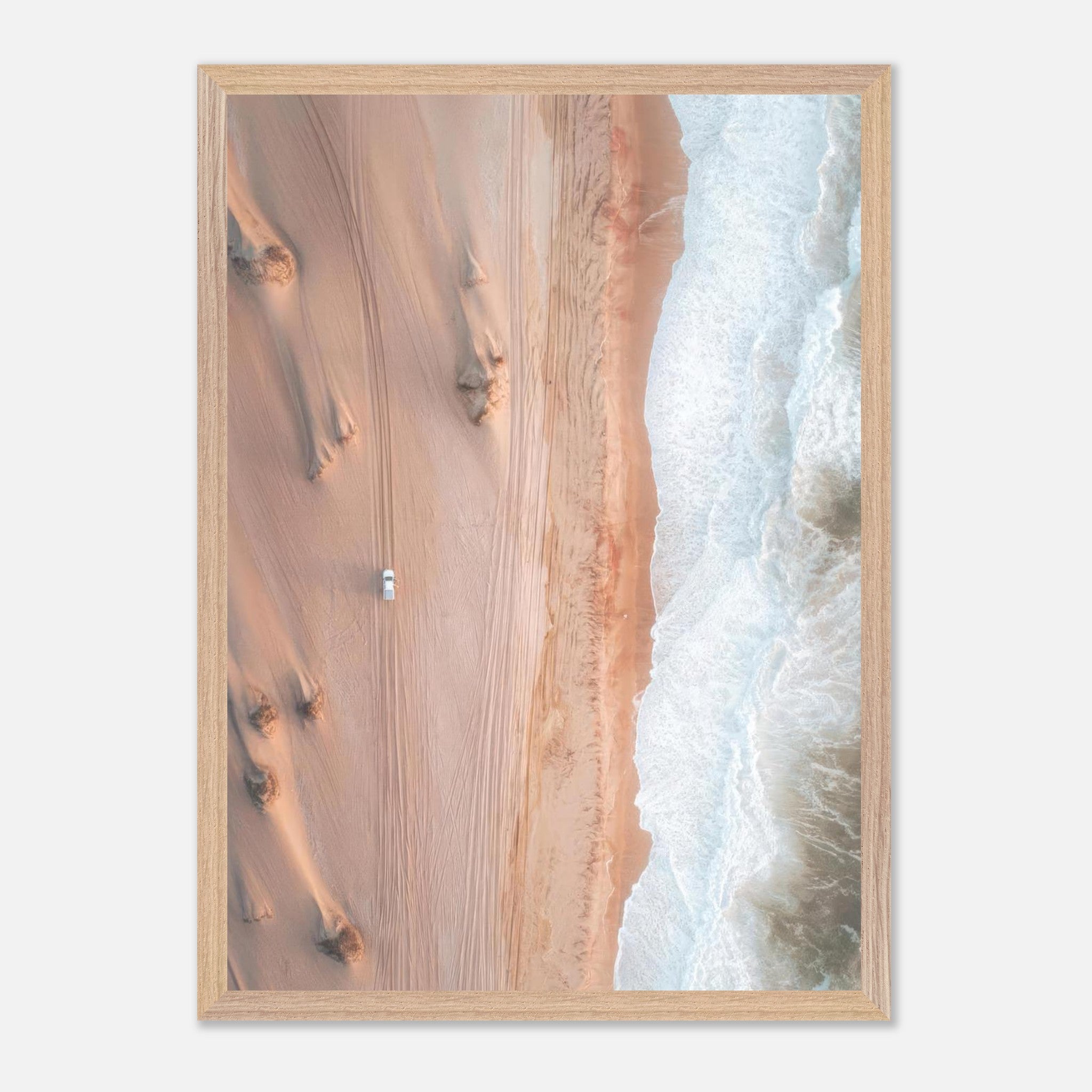 Drone photography print of desert and ocean showcasing golden dunes and blue waves in a vintage frame.
