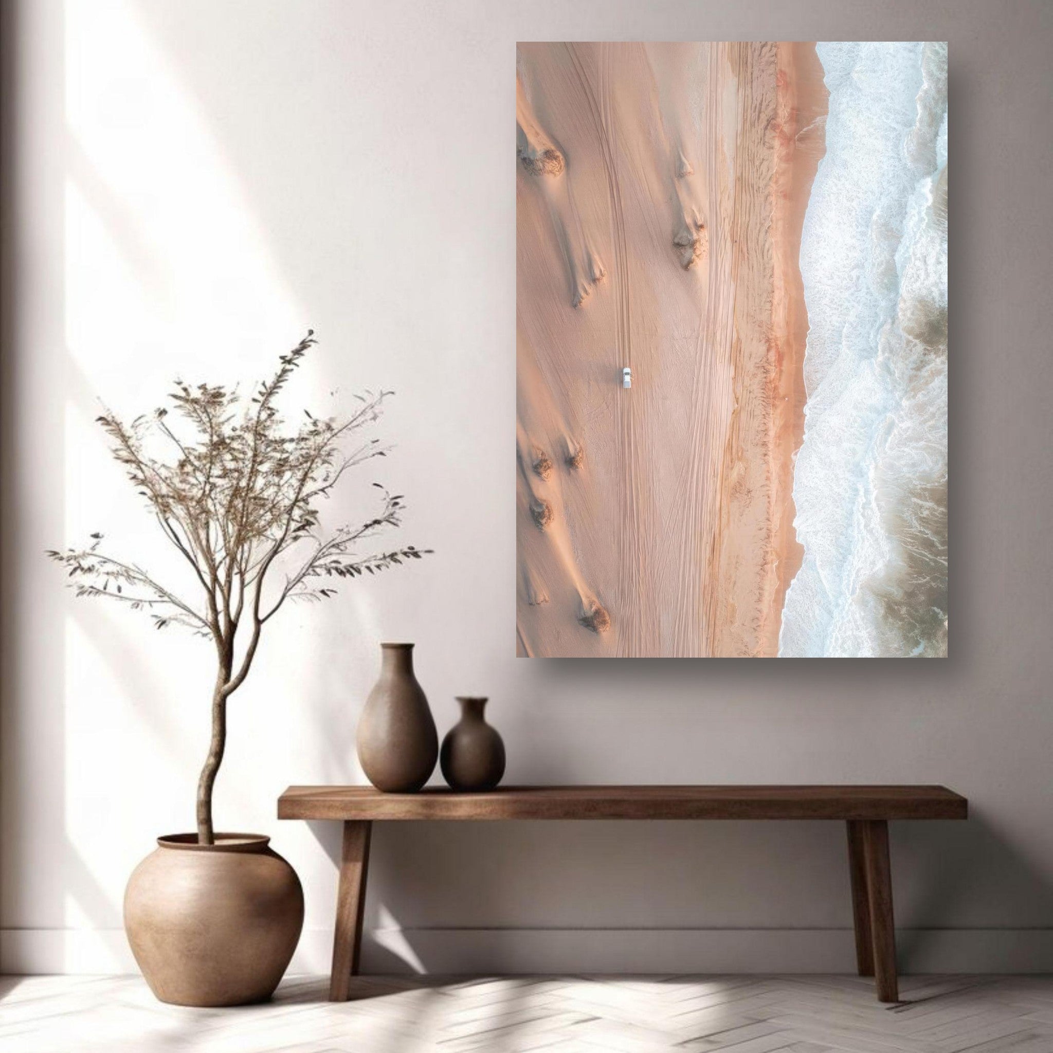 Aerial view of desert meeting ocean in metal print, showcasing sand dunes and waves, displayed on a wall.