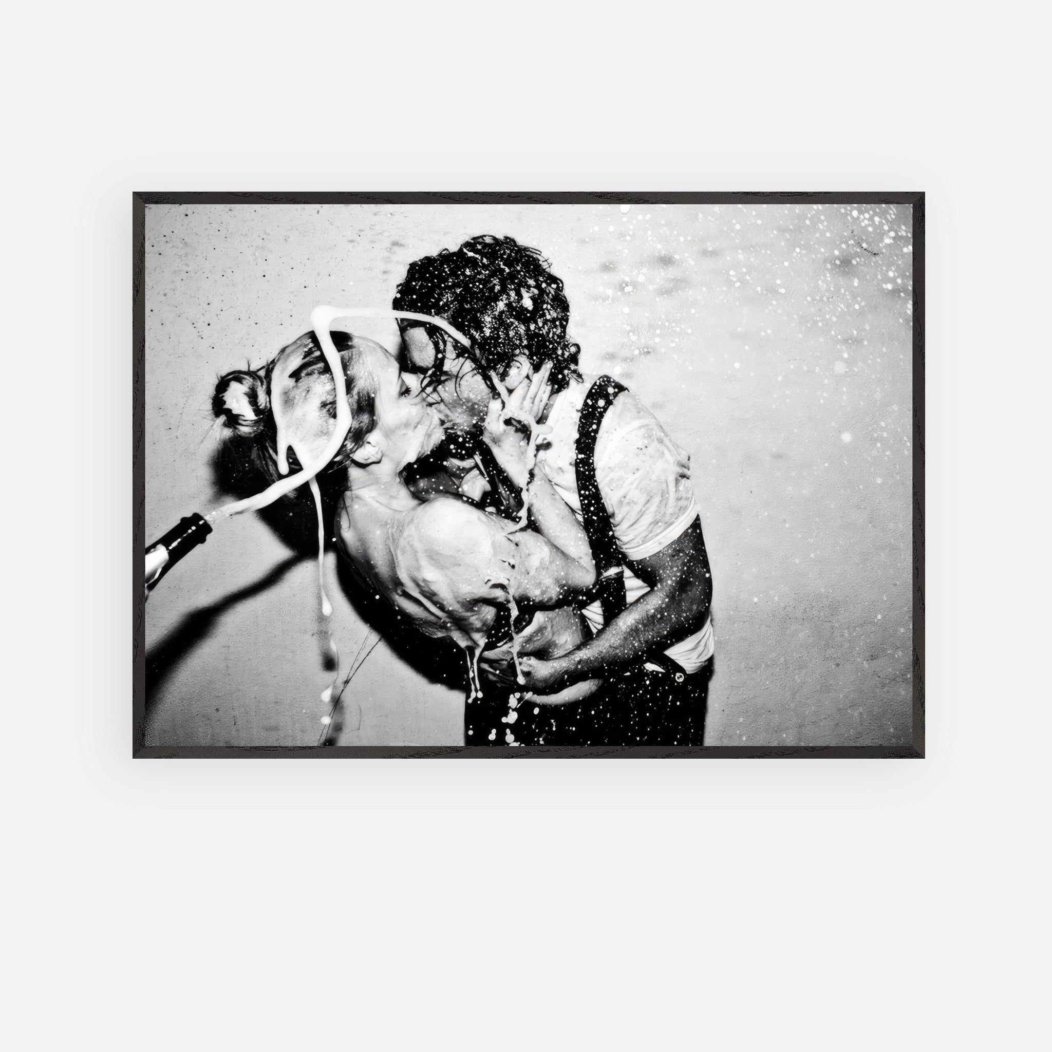 Black-and-white fine art print of a passionate kiss between a couple with champagne splashes, titled The Champagne Kiss.