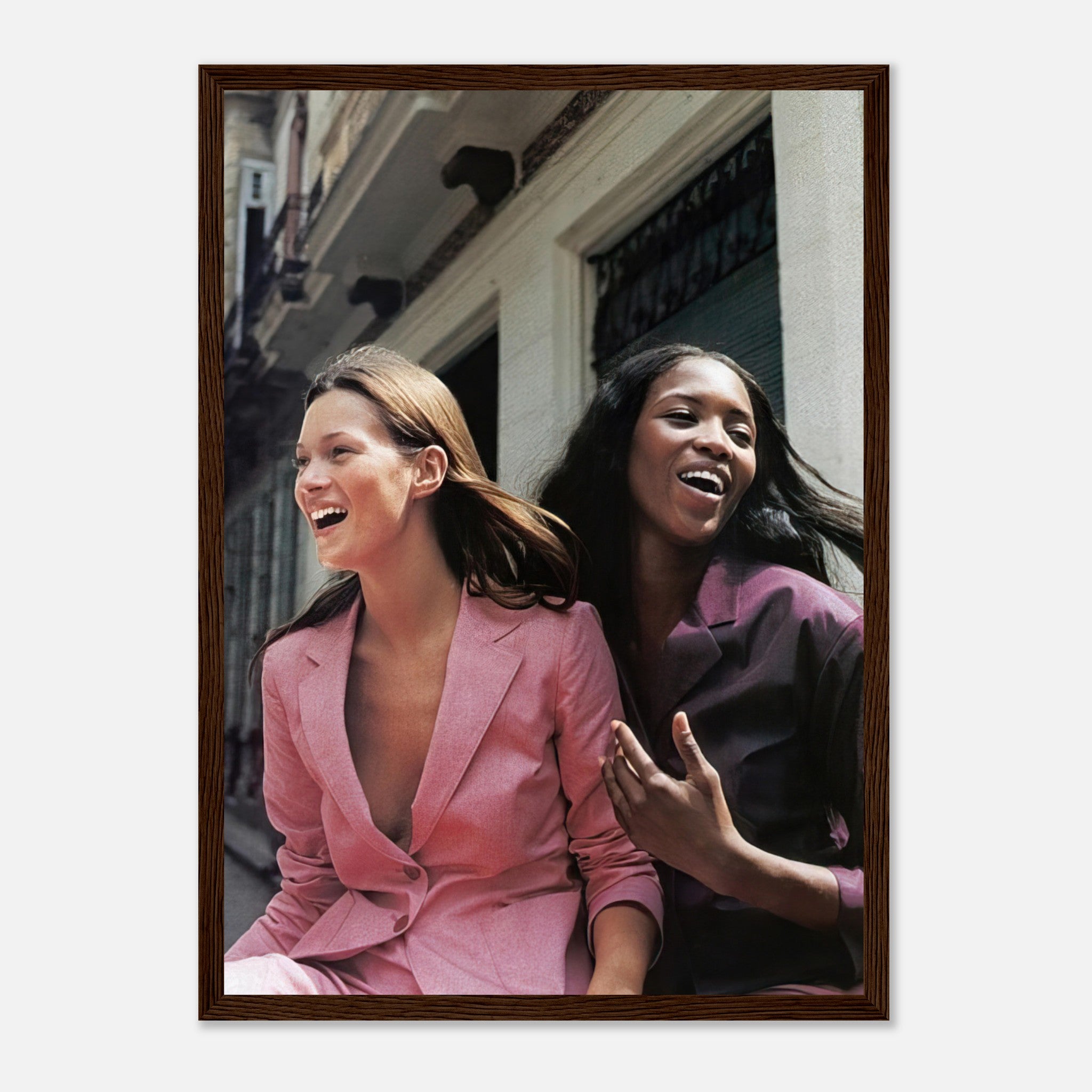 Naomi Campbell and Kate Moss laughing in stylish suits framed print, capturing the essence of 90s fashion elegance.