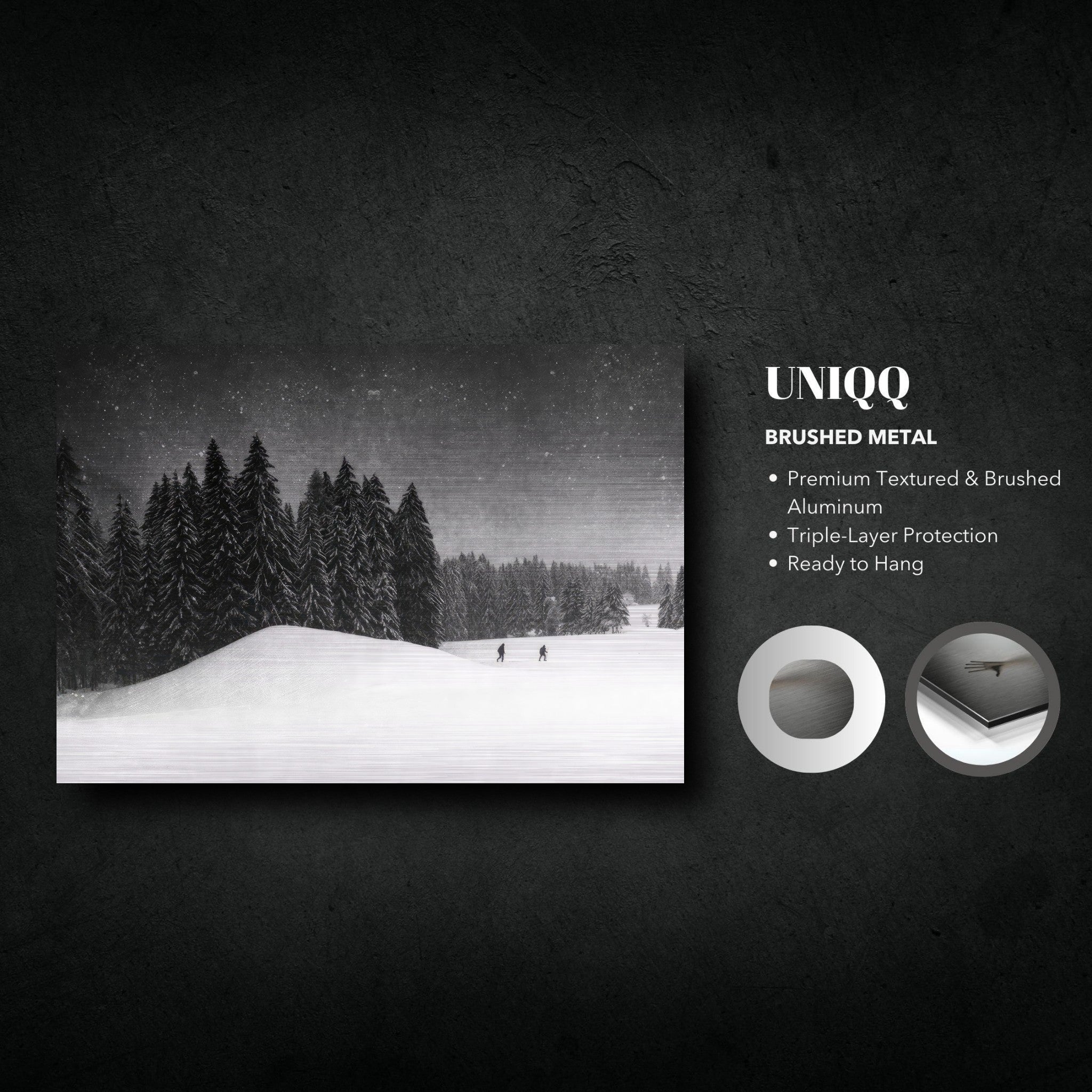 Brushed metal artwork "Winter Crossing" depicting a snowy forest landscape with figures walking under a starry sky.