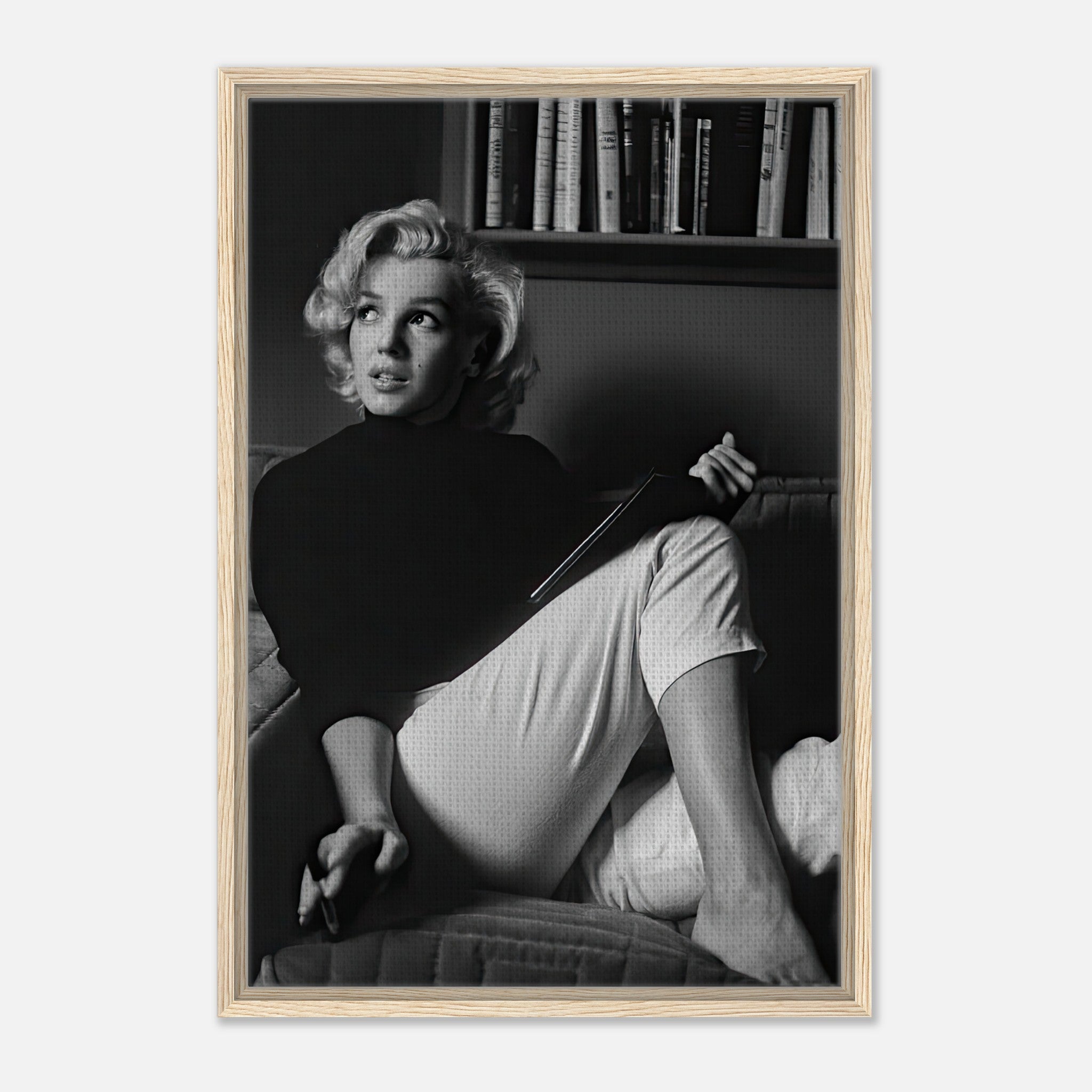 Marilyn Monroe reading a book in black-and-white framed canvas print, showcasing elegance and charm.