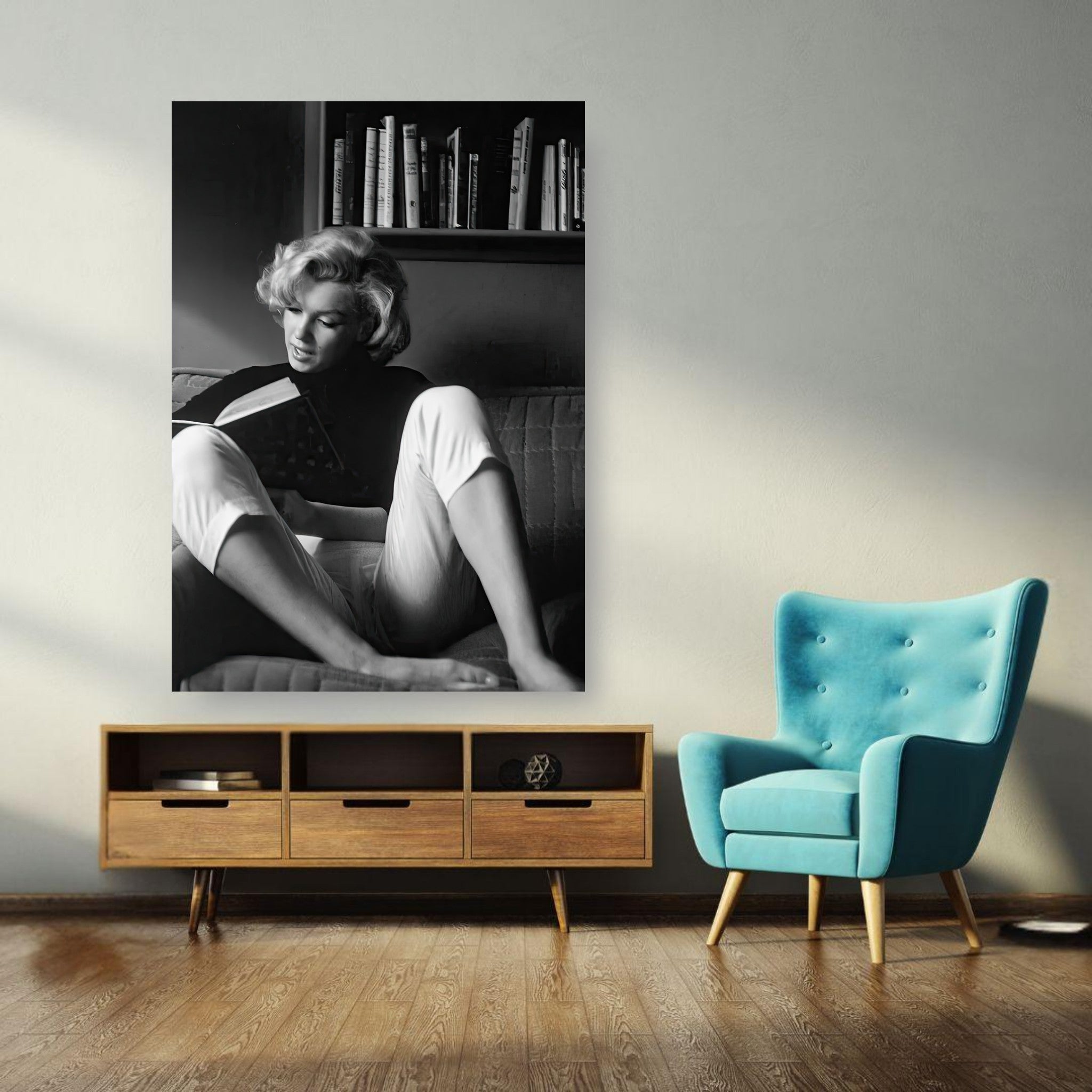 Marilyn Monroe Reading at Home Poster in black-and-white, showcasing her relaxed on a sofa with books in the background.