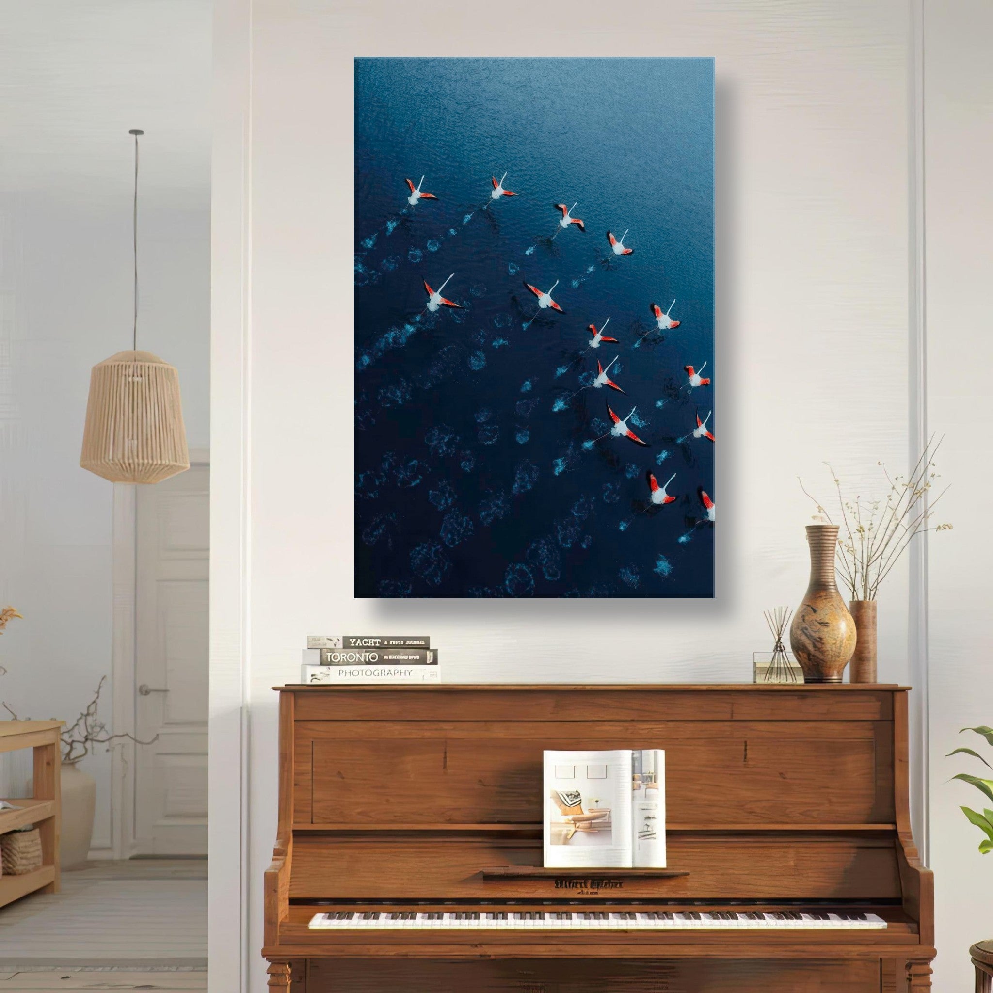 Aerial view of flamingos flying over deep blue water, showcased as a canvas print in a stylish home decor.