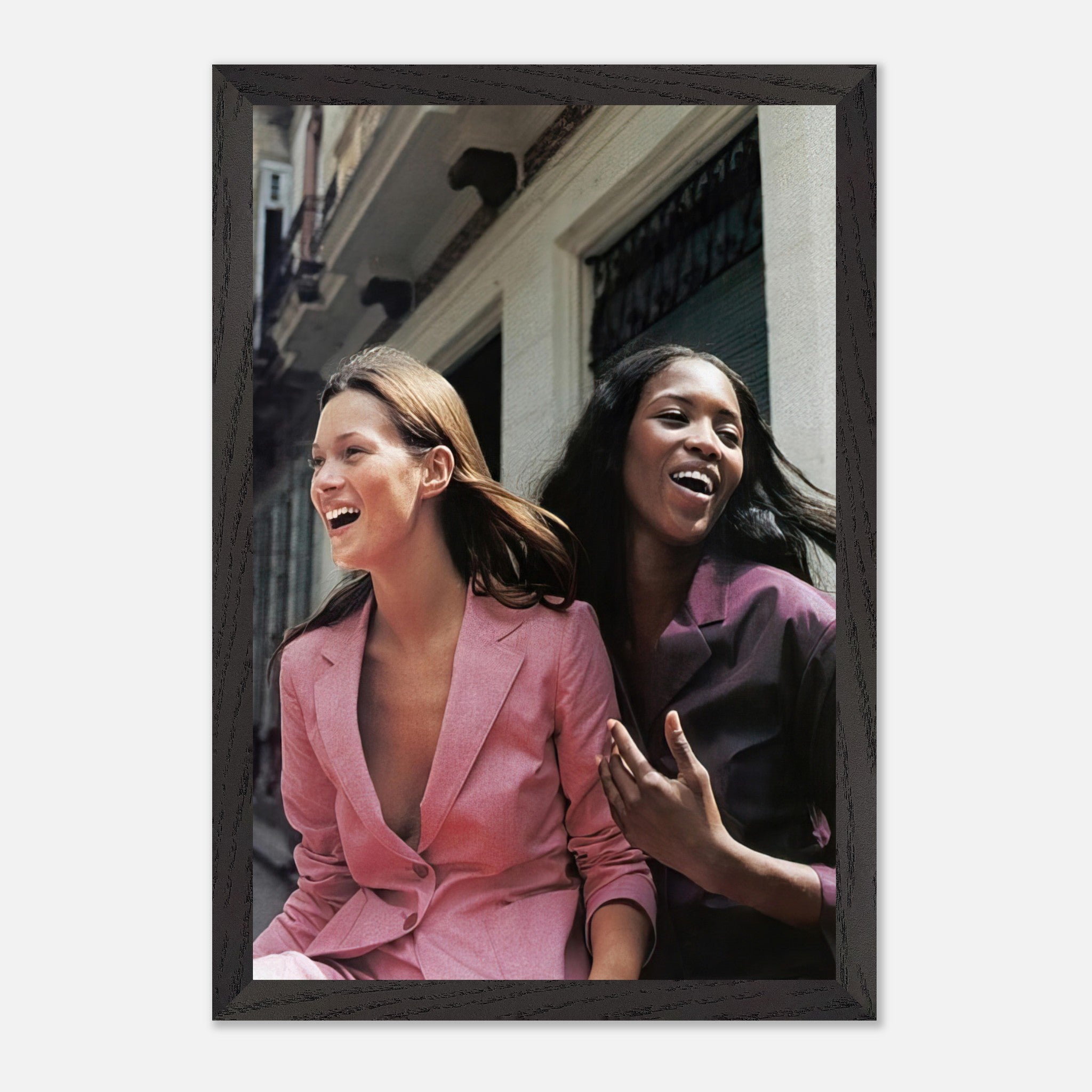 Naomi Campbell and Kate Moss laughing together in vibrant outfits, showcasing the essence of high fashion and friendship.