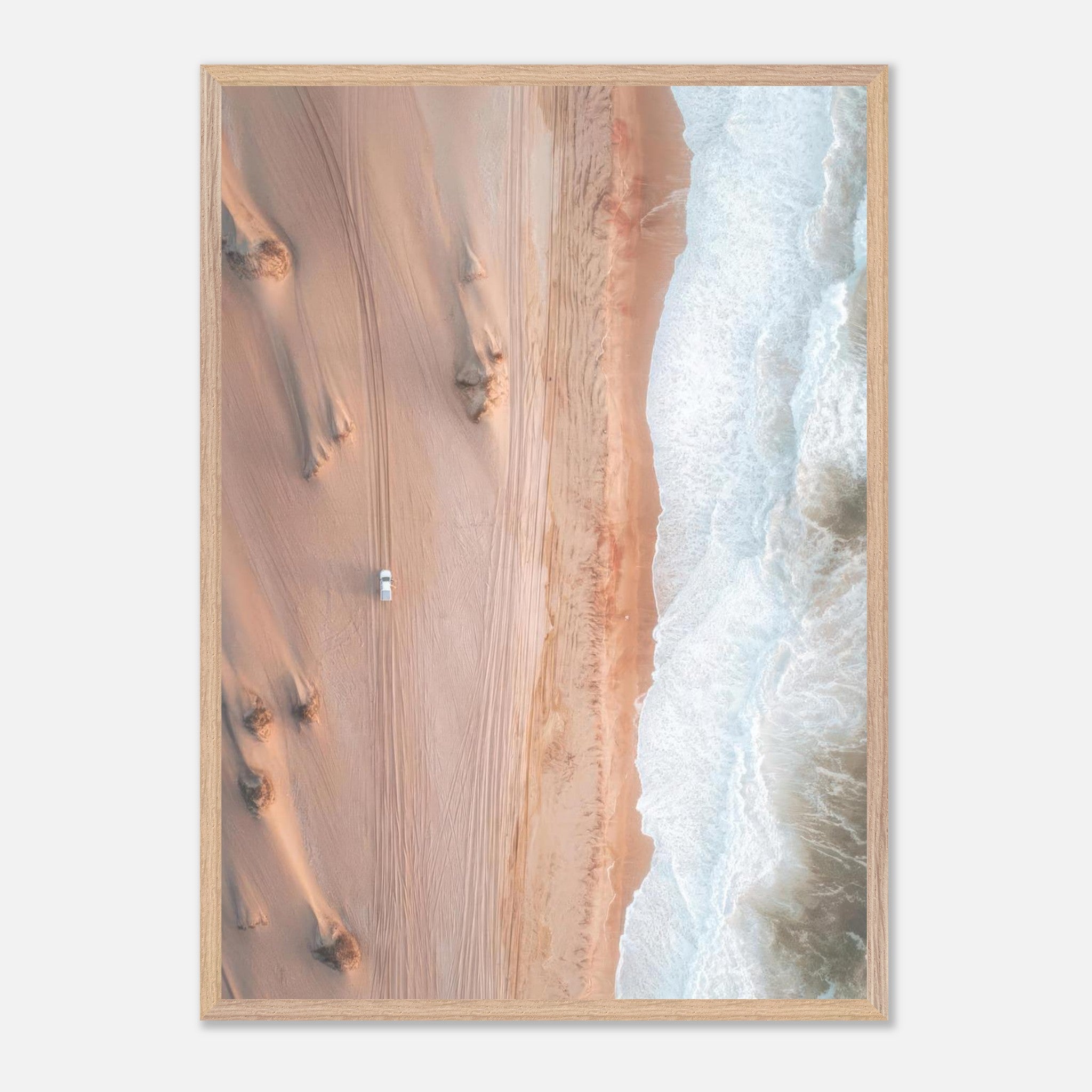 Aerial view of golden dunes meeting turquoise ocean waves in a fine art drone photograph.