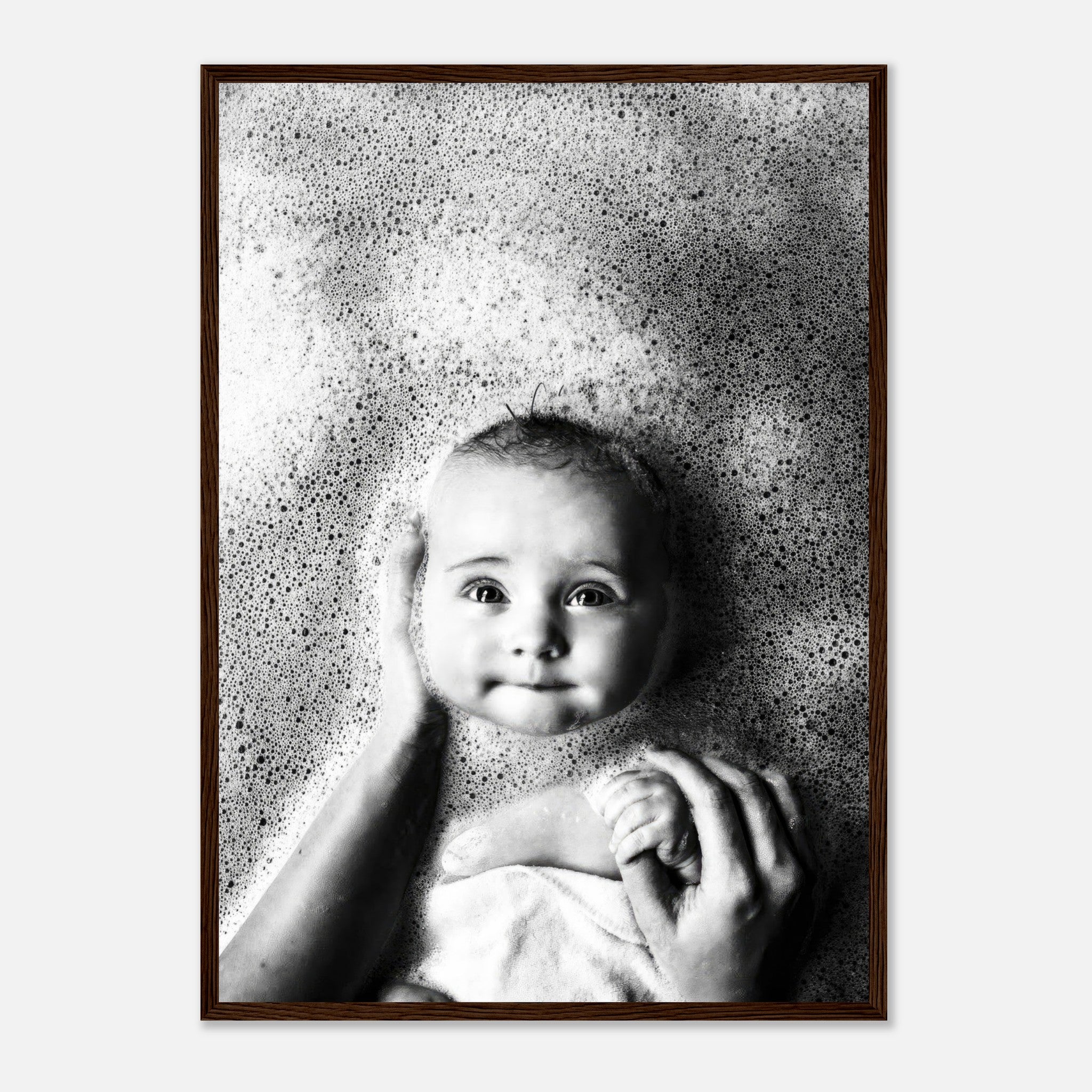 Black-and-white framed print of a baby enjoying bath time surrounded by bubbles.