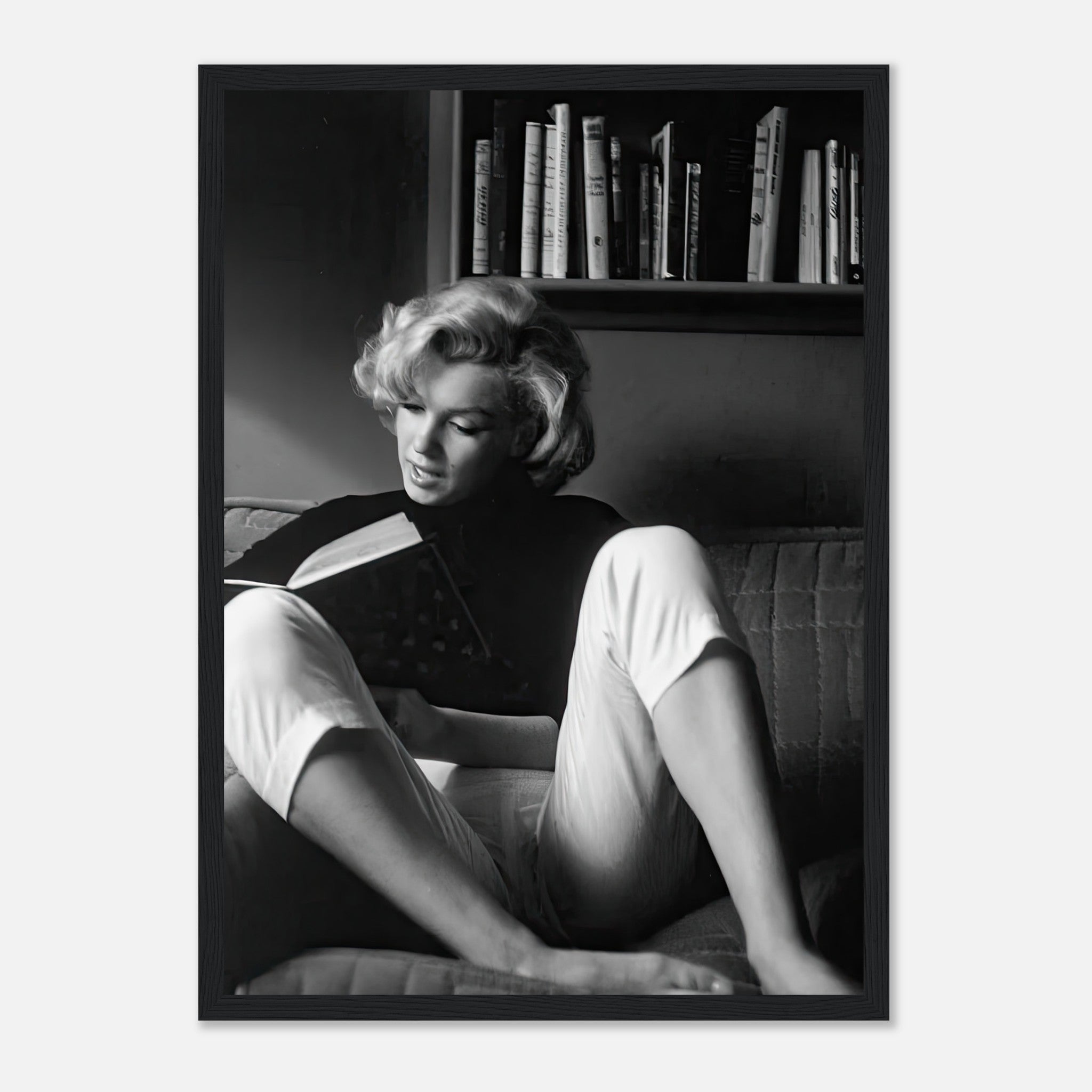 Marilyn Monroe reading a book at home in a framed print, exuding classic Hollywood sophistication.