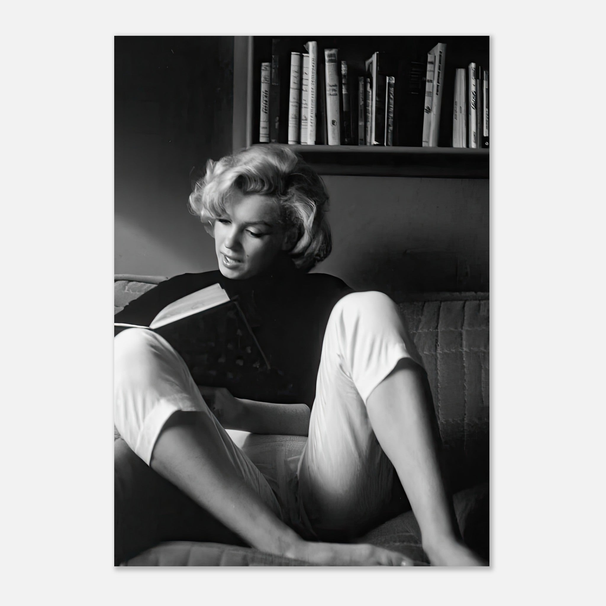 Marilyn Monroe reading a book at home, captured in a black-and-white vintage poster.