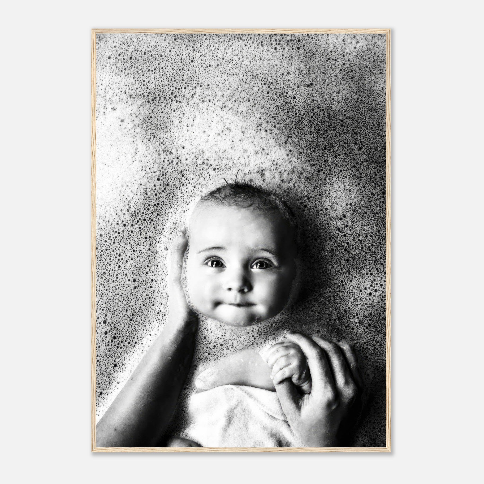 Framed black-and-white print of a baby in bubbles, showcasing pure joy and innocence during bath time.