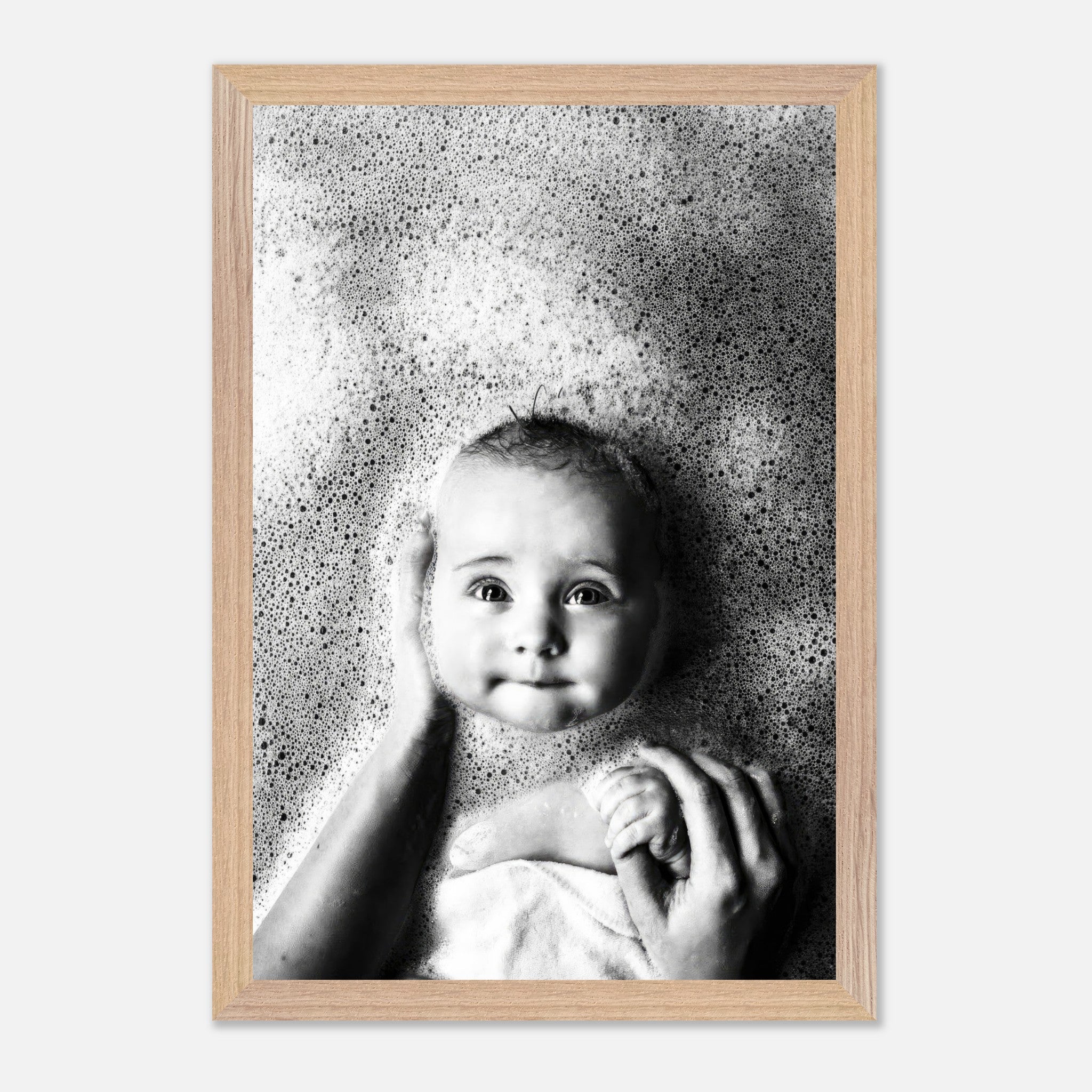 Stunning black-and-white baby bath photography capturing innocent joy and tenderness with soft bubbles surrounding a smiling baby.