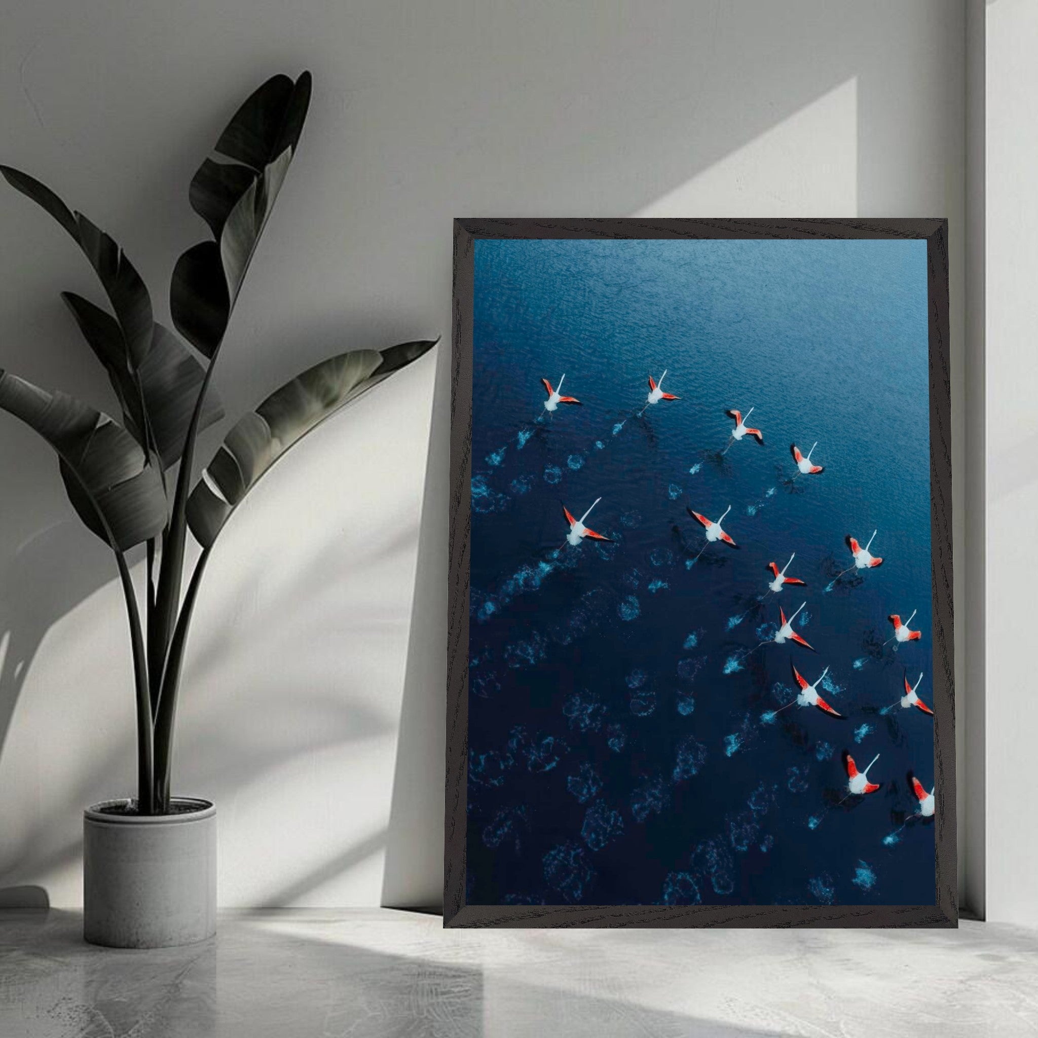 Aerial view of flamingos in motion over deep azure waters, captured in high-resolution fine art print.