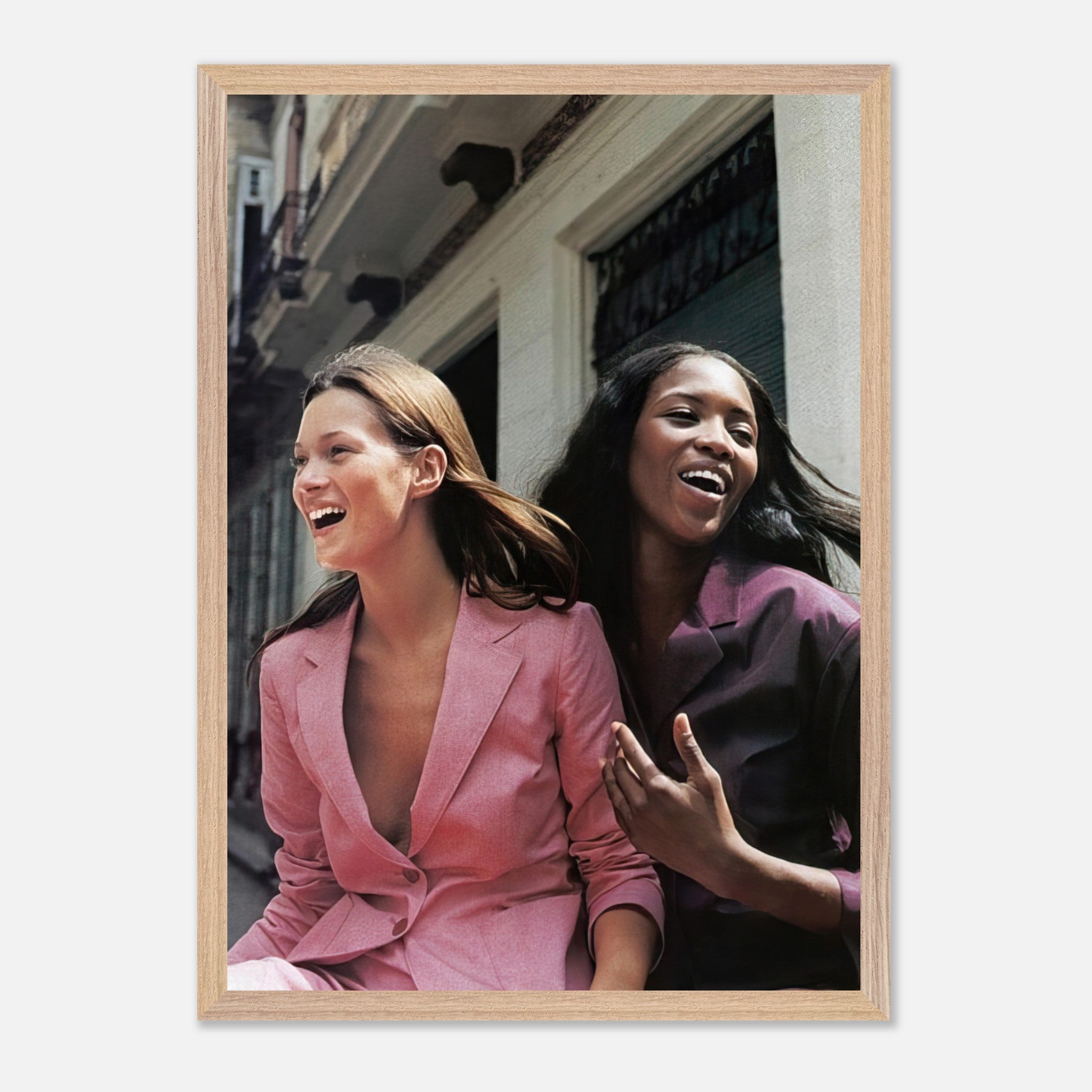 Naomi Campbell and Kate Moss sharing a joyful moment in stylish outfits, capturing the essence of high fashion and friendship.