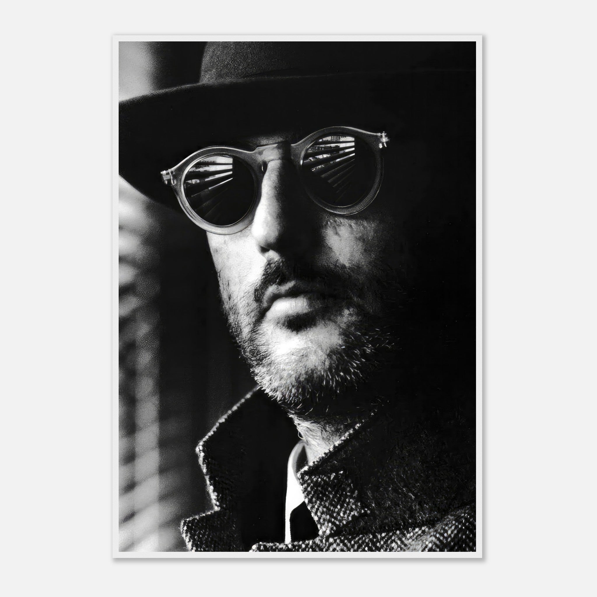 Jean Reno Leon black-and-white framed print featuring a man in sunglasses and a hat, exuding mystery and elegance.