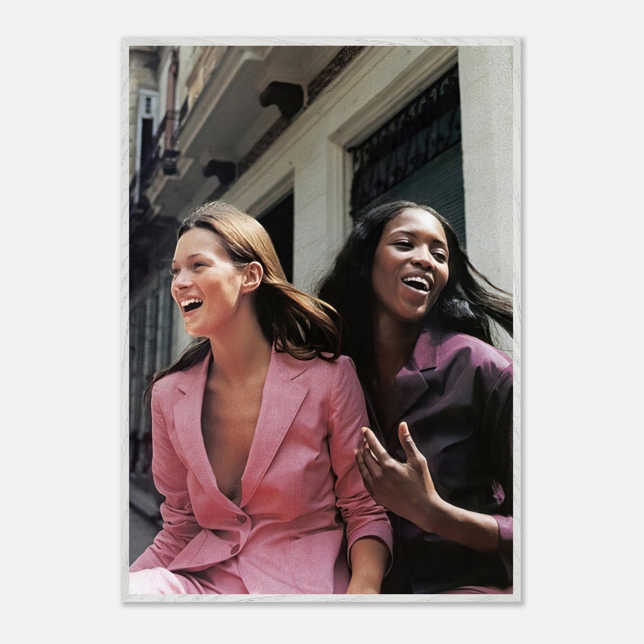 Naomi Campbell and Kate Moss laughing together in stylish suits, capturing high fashion friendship in a fine art print.