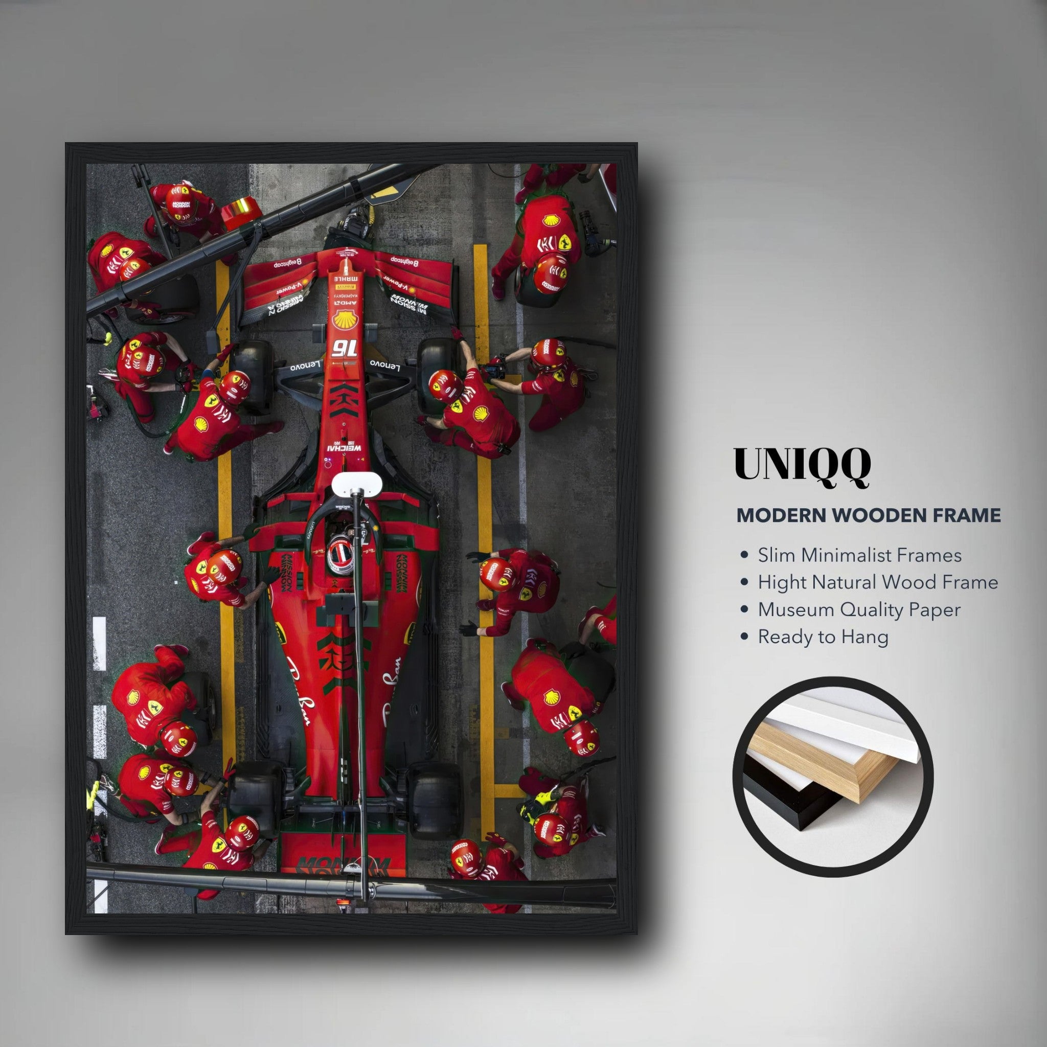 Framed print of a Formula 1 Ferrari pitstop, showcasing pit crew in action with vivid red details and modern Wood frame.