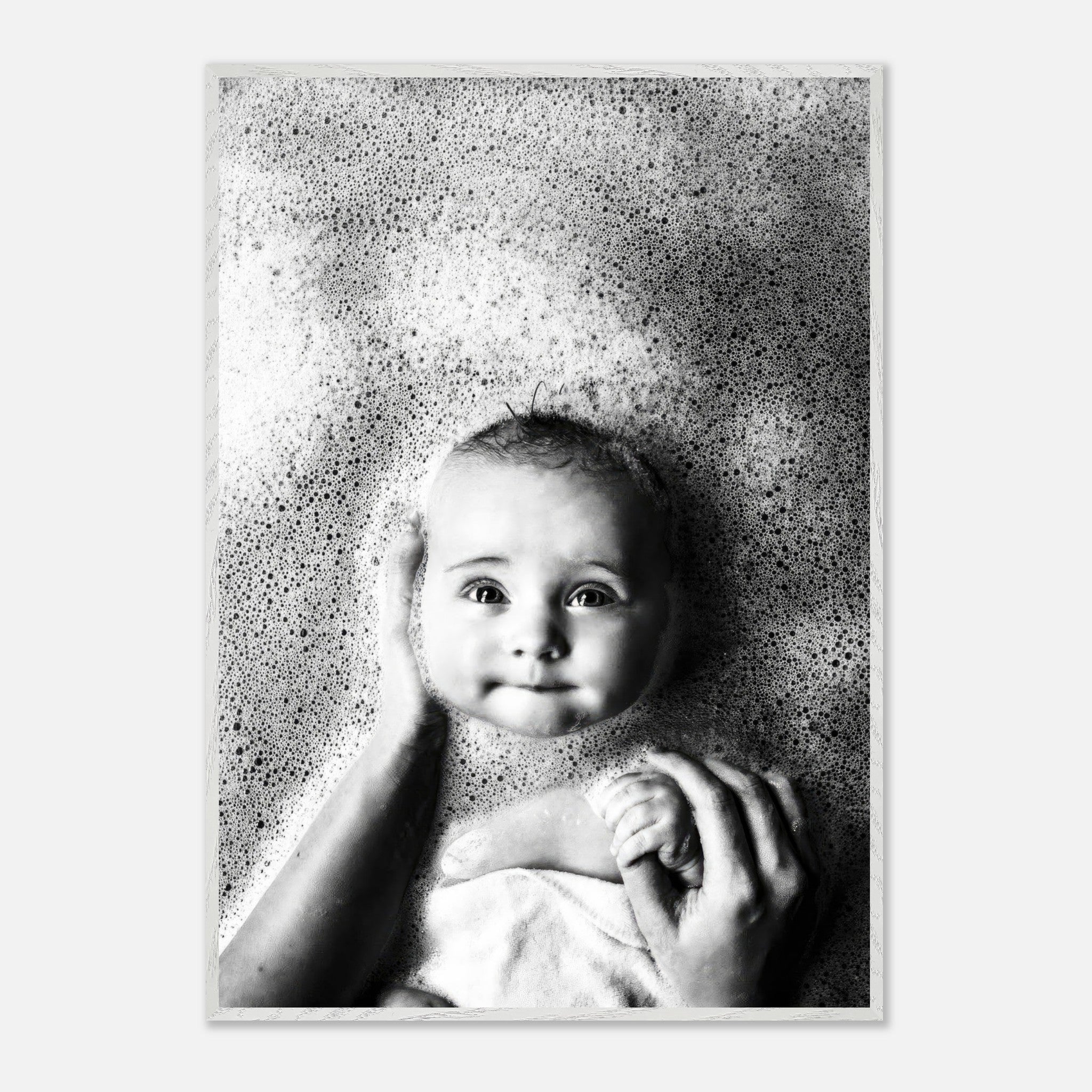 Black-and-white baby bath photography print showcasing a smiling baby surrounded by bubbles, conveying innocence and joy.