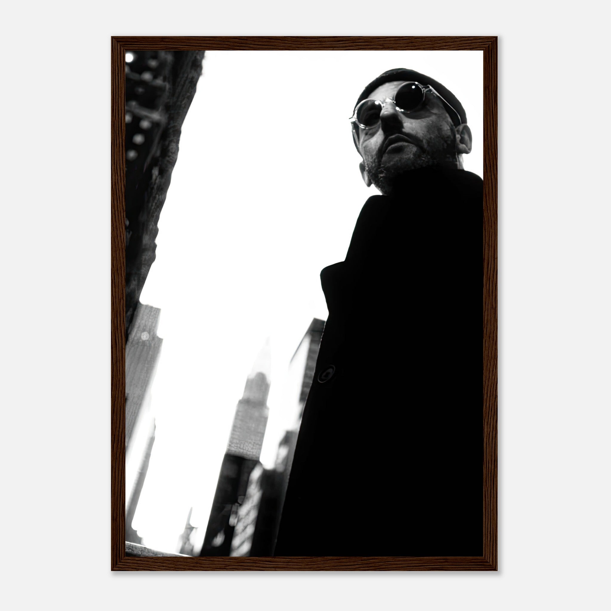 Black-and-white framed print of Jean Reno in urban setting, showcasing cinematic artistry and timeless style.