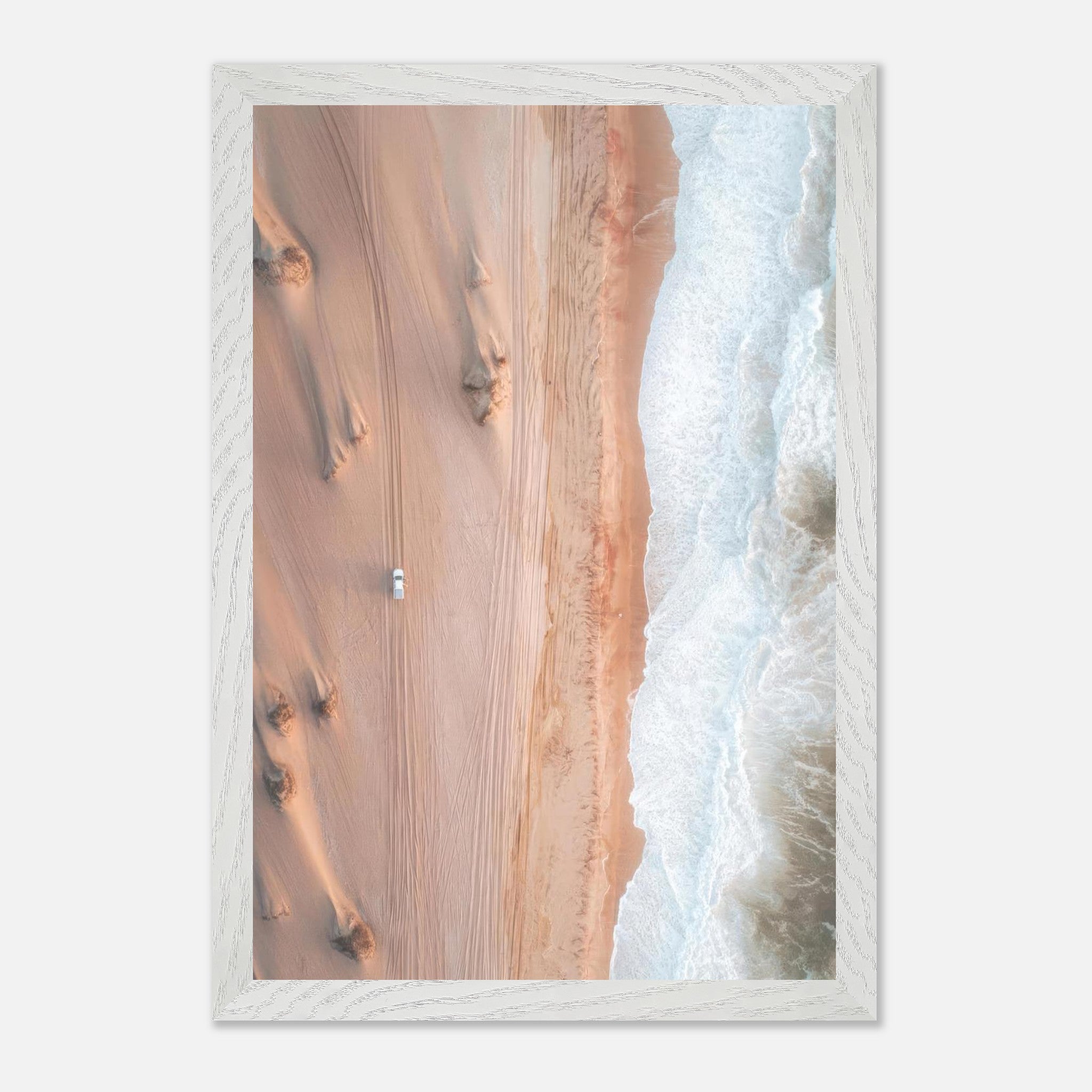 Aerial view of golden dunes meeting the ocean wave, captured in fine art drone photography.