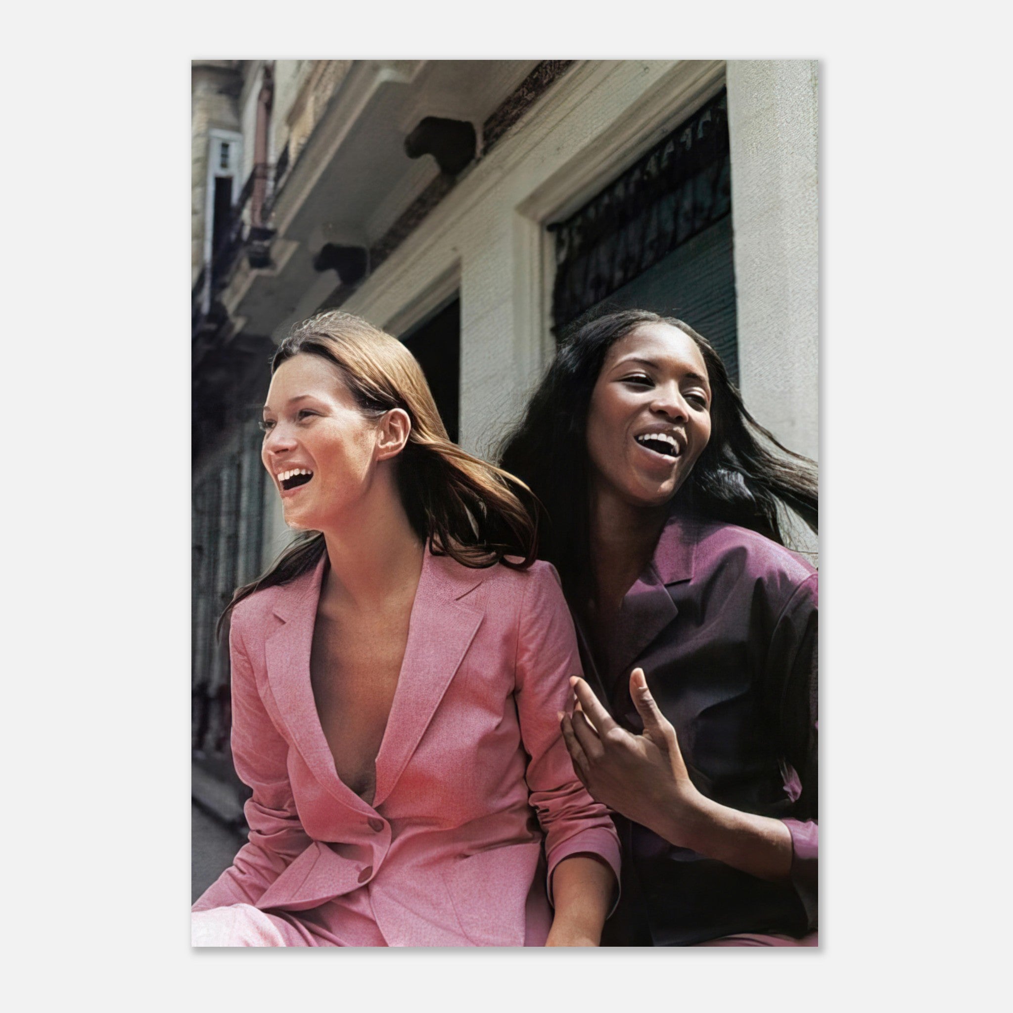 Naomi Campbell and Kate Moss laughing together in stylish outfits, capturing elegance and joy in this fashion poster.