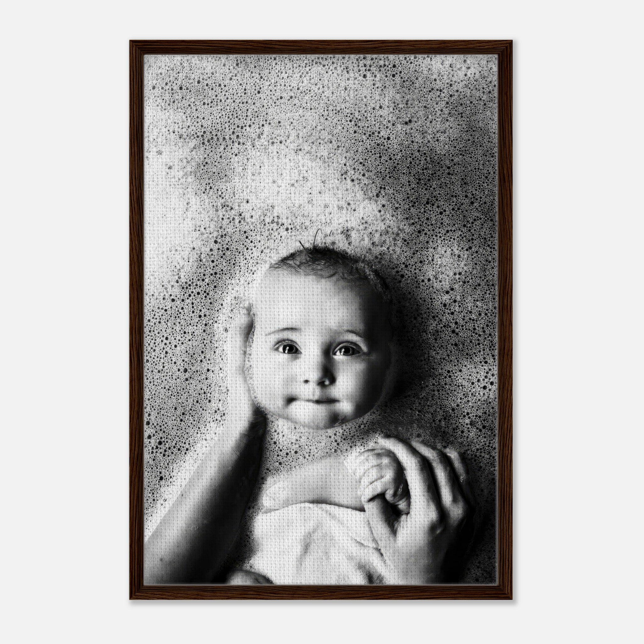 Baby in a bubble bath being held, captured in heartwarming black-and-white photography, framed canvas print.