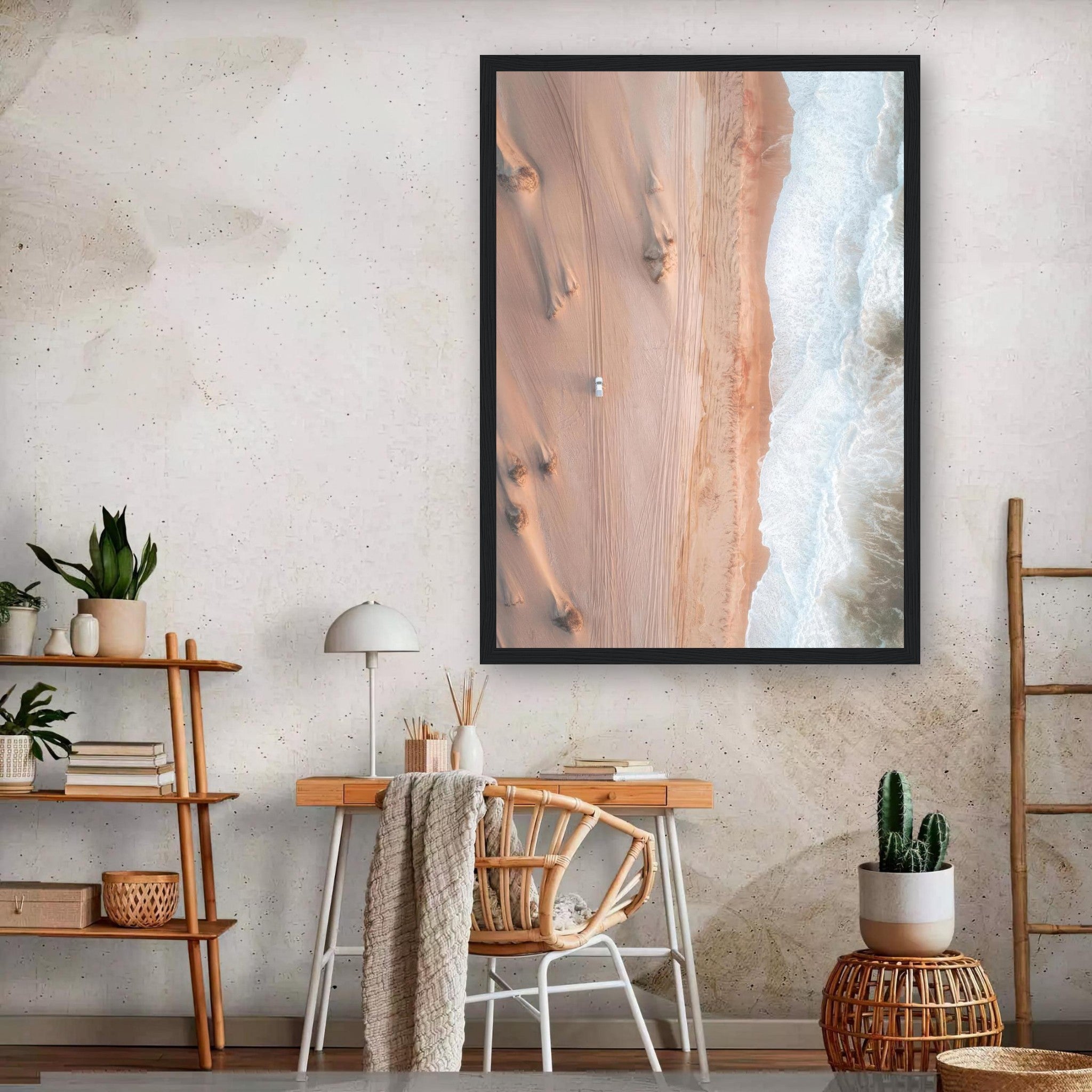 Framed drone photography print of desert sands meeting ocean waves in a stylish home interior.