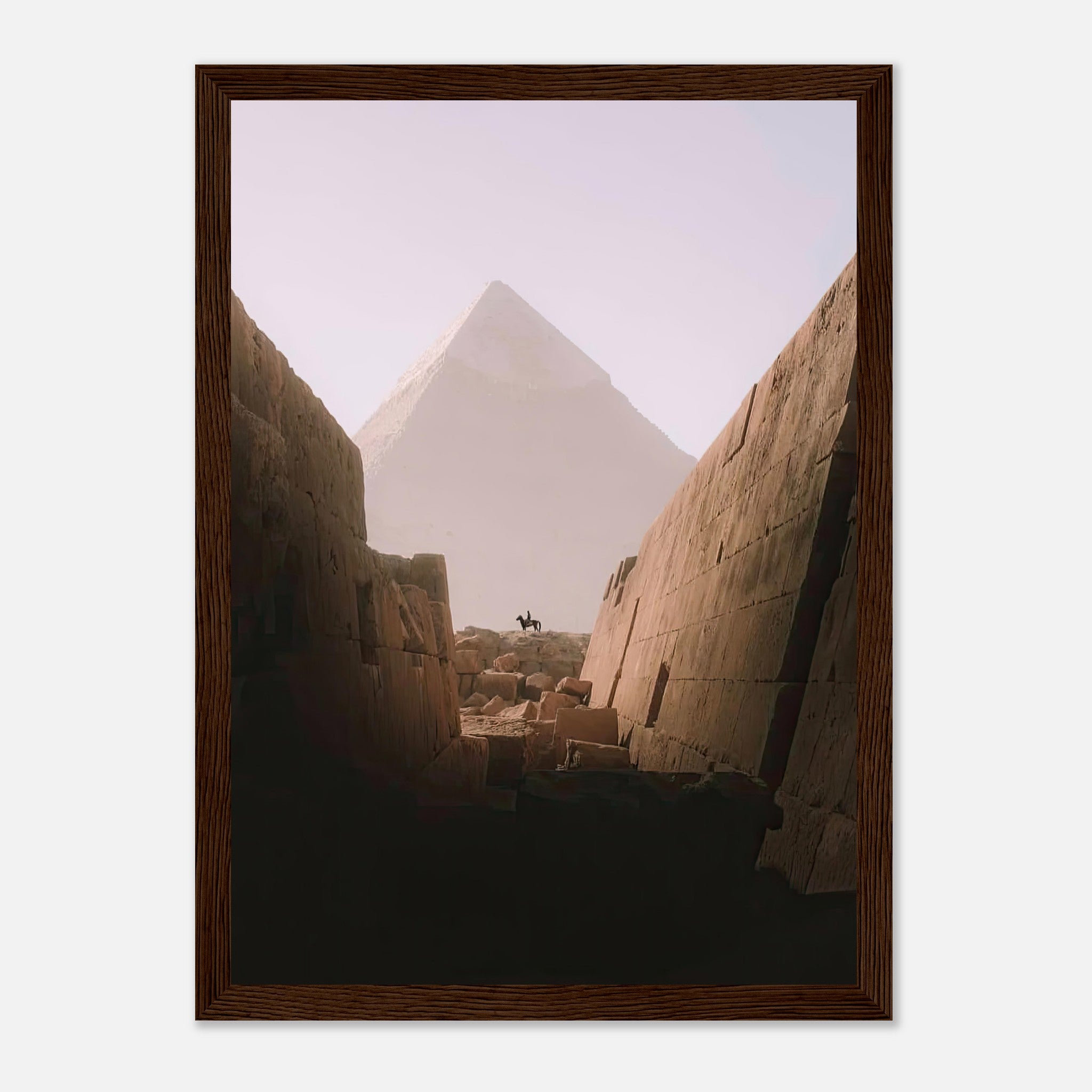 Framed print of a lone rider silhouetted against the Great Pyramid of Giza, framed by ancient stone walls.